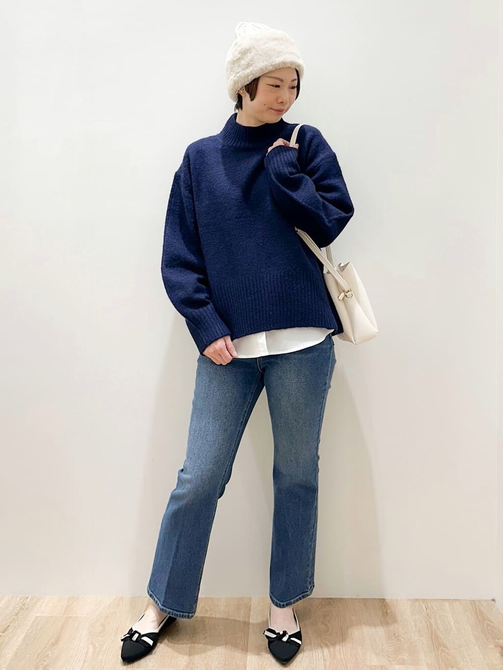 ブルー系のニット/セーター、ホワイト系のTシャツ/カットソー、ブルー系のデニムパンツを着用したレディースの冬コーディネートの6枚目の写真