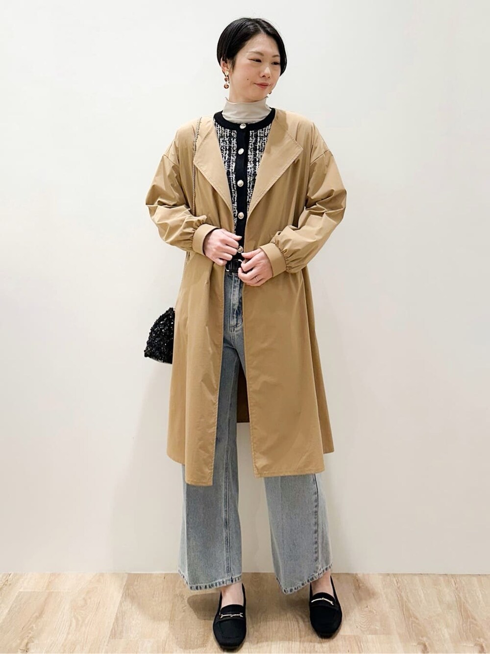 ブラック系のカーディガン/ボレロ、グレー系のTシャツ/カットソー、ブルー系のデニムパンツを着用したレディースの冬コーディネートの3枚目の写真
