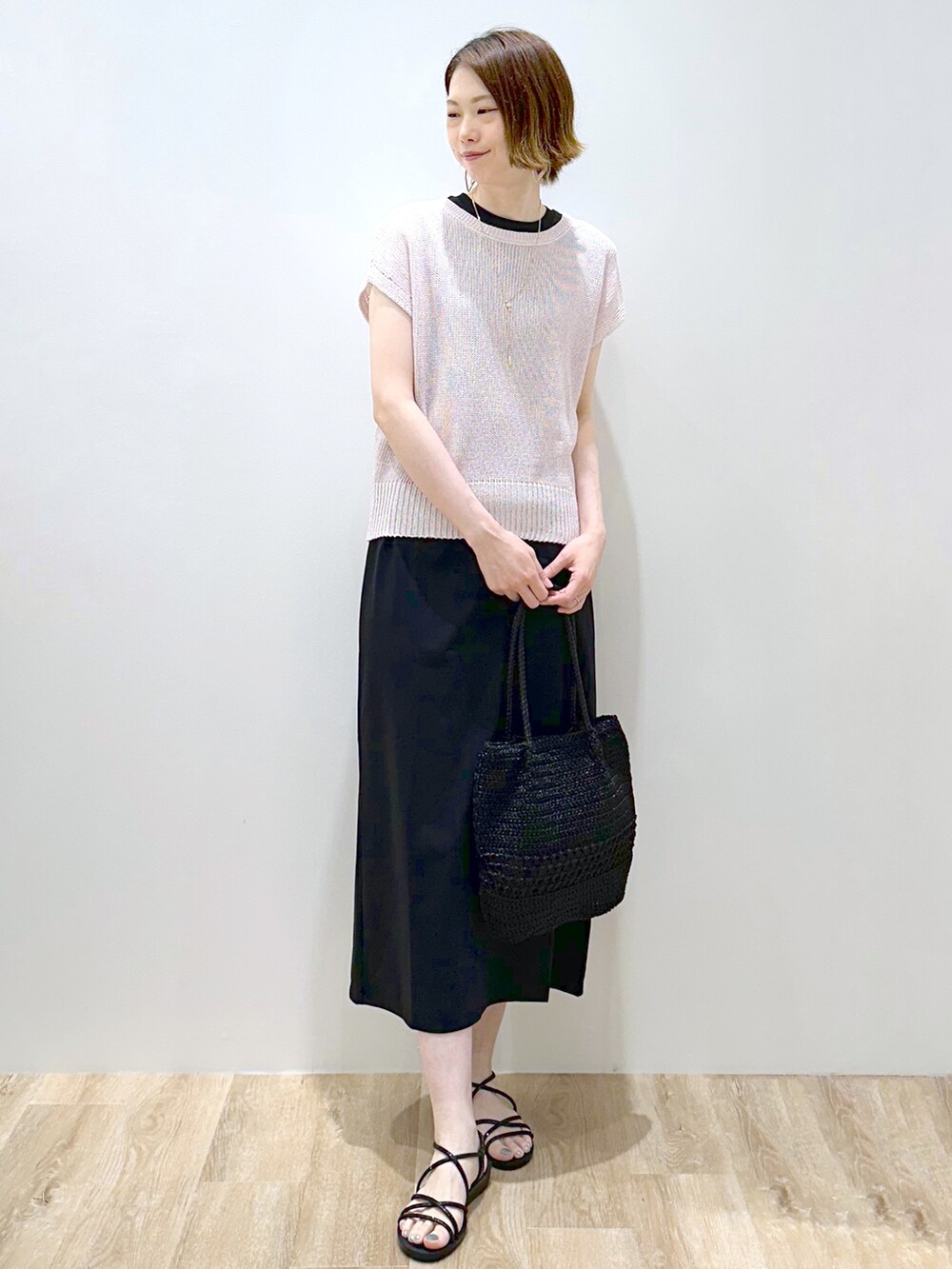 ピンク系のニット/セーター、ブラック系のトートバッグ、ブラック系のサンダルを着用したレディースの夏コーディネートの2枚目の写真