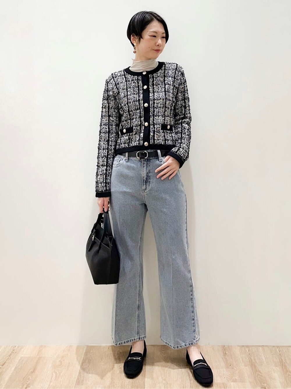 ブラック系のカーディガン/ボレロ、グレー系のTシャツ/カットソー、ブルー系のデニムパンツを着用したレディースの冬コーディネートの4枚目の写真