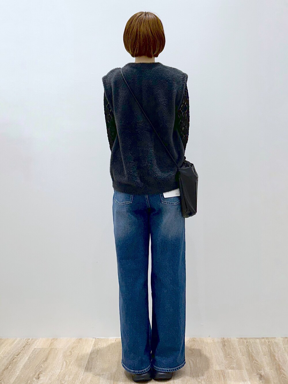 グレー系のニット/セーター、ブラック系のカーディガン/ボレロ、ブルー系のデニムパンツを着用したレディースの秋コーディネートの4枚目の写真