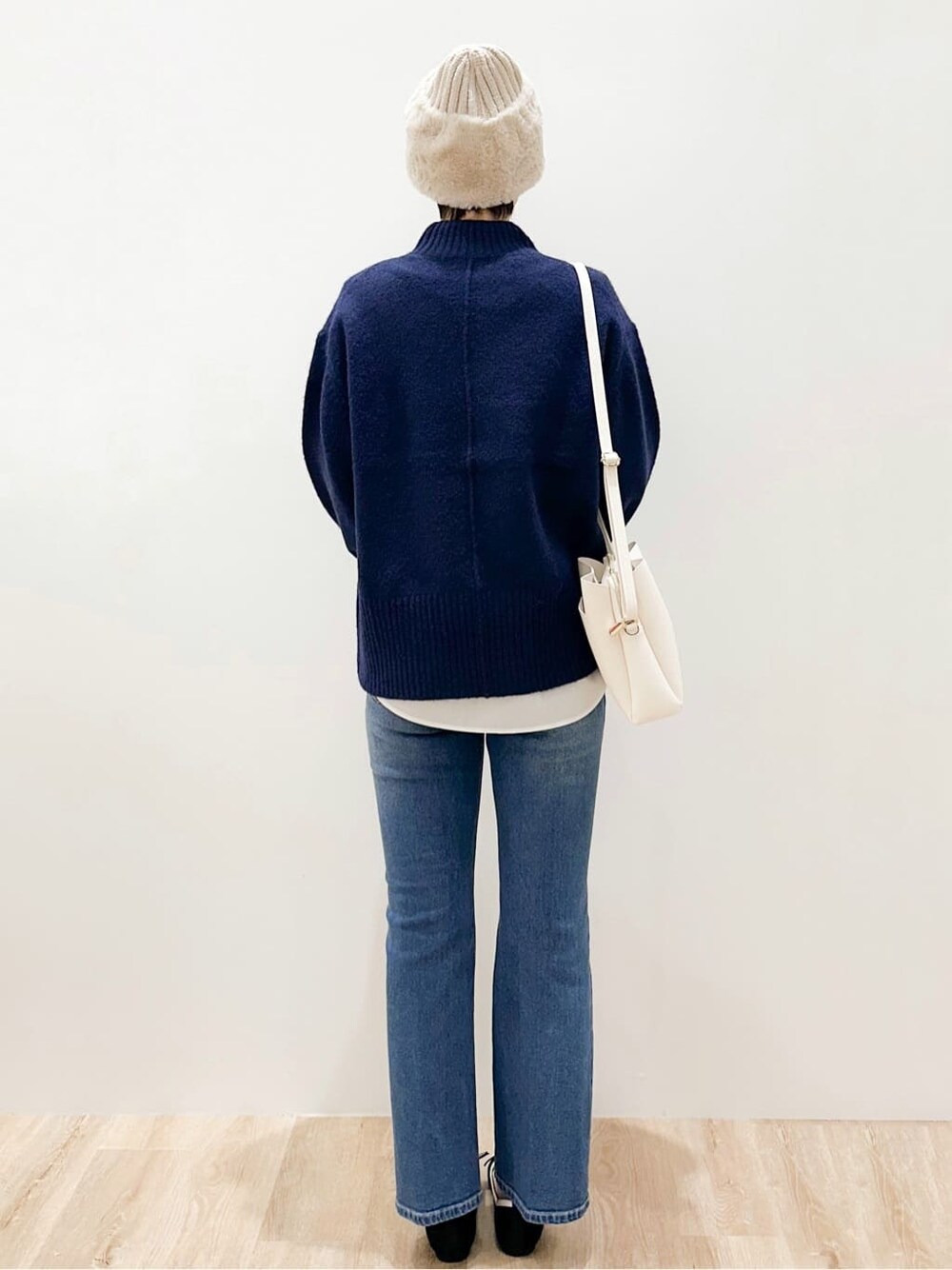 ブルー系のニット/セーター、ホワイト系のTシャツ/カットソー、ブルー系のデニムパンツを着用したレディースの冬コーディネートの3枚目の写真