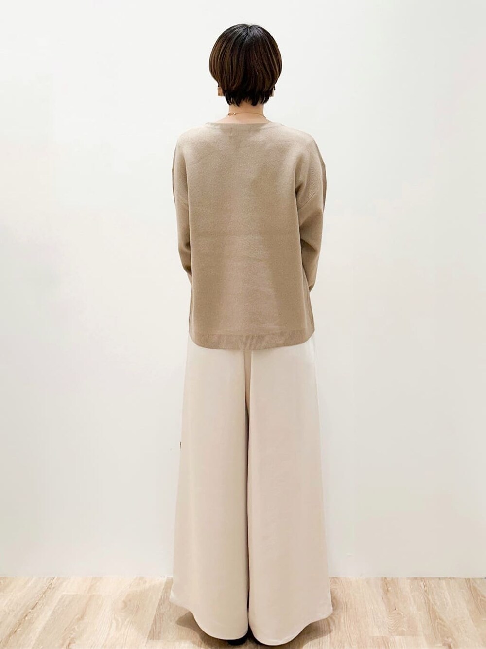ベージュ系のニット/セーター、ホワイト系のその他パンツ、ベージュ系のトートバッグを着用したレディースの冬コーディネートの4枚目の写真