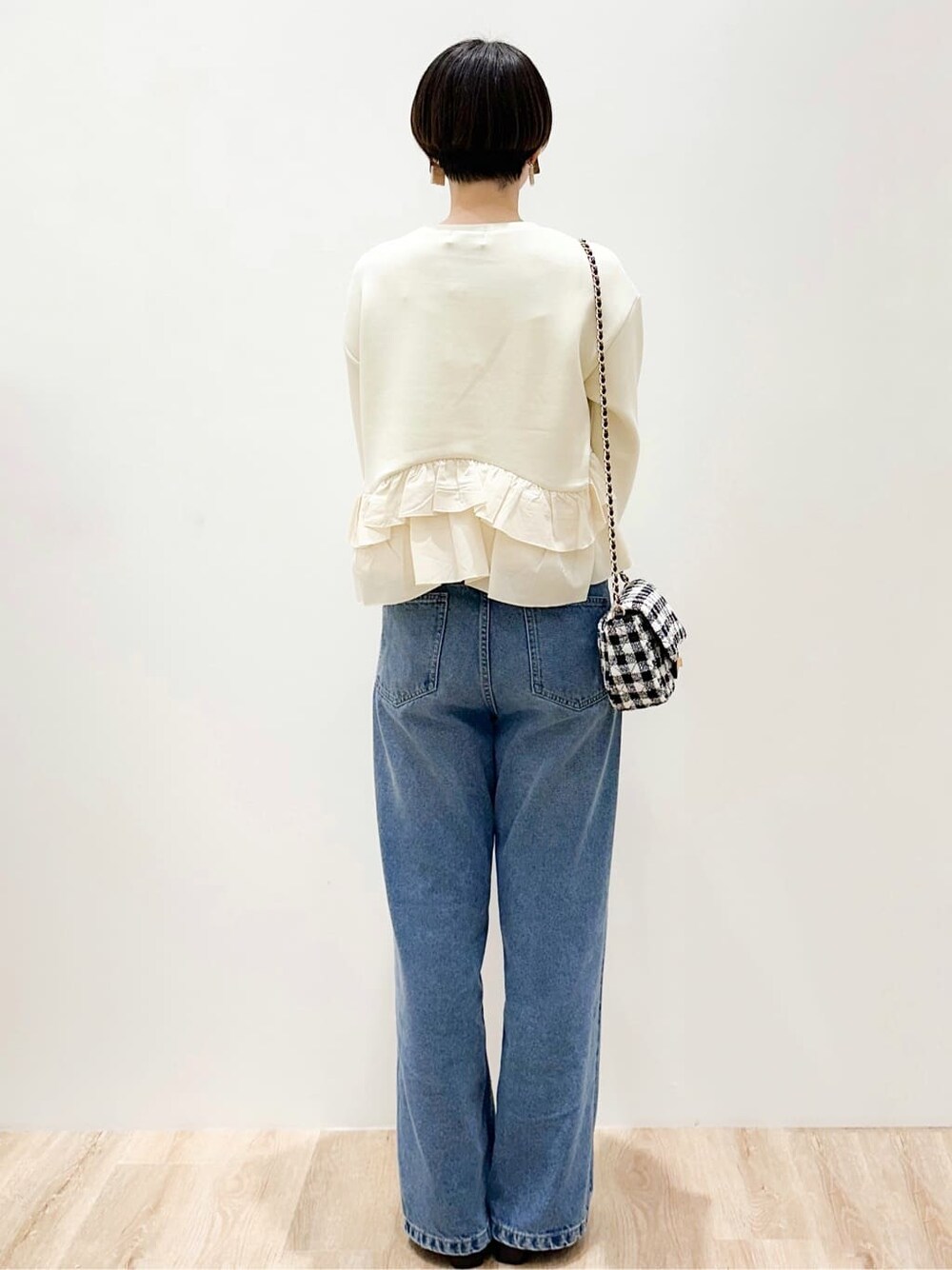 イエロー系のTシャツ/カットソー、ブルー系のデニムパンツ、ブラック系のショルダーバッグを着用したレディースの春コーディネートの4枚目の写真