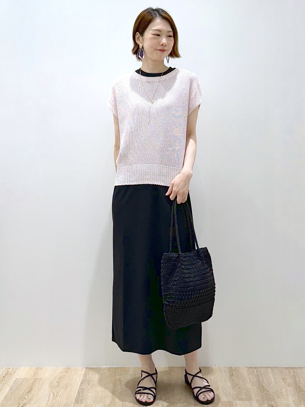 ピンク系のニット/セーター、ブラック系のトートバッグ、ブラック系のサンダルを着用したレディースの夏コーディネートの5枚目の写真
