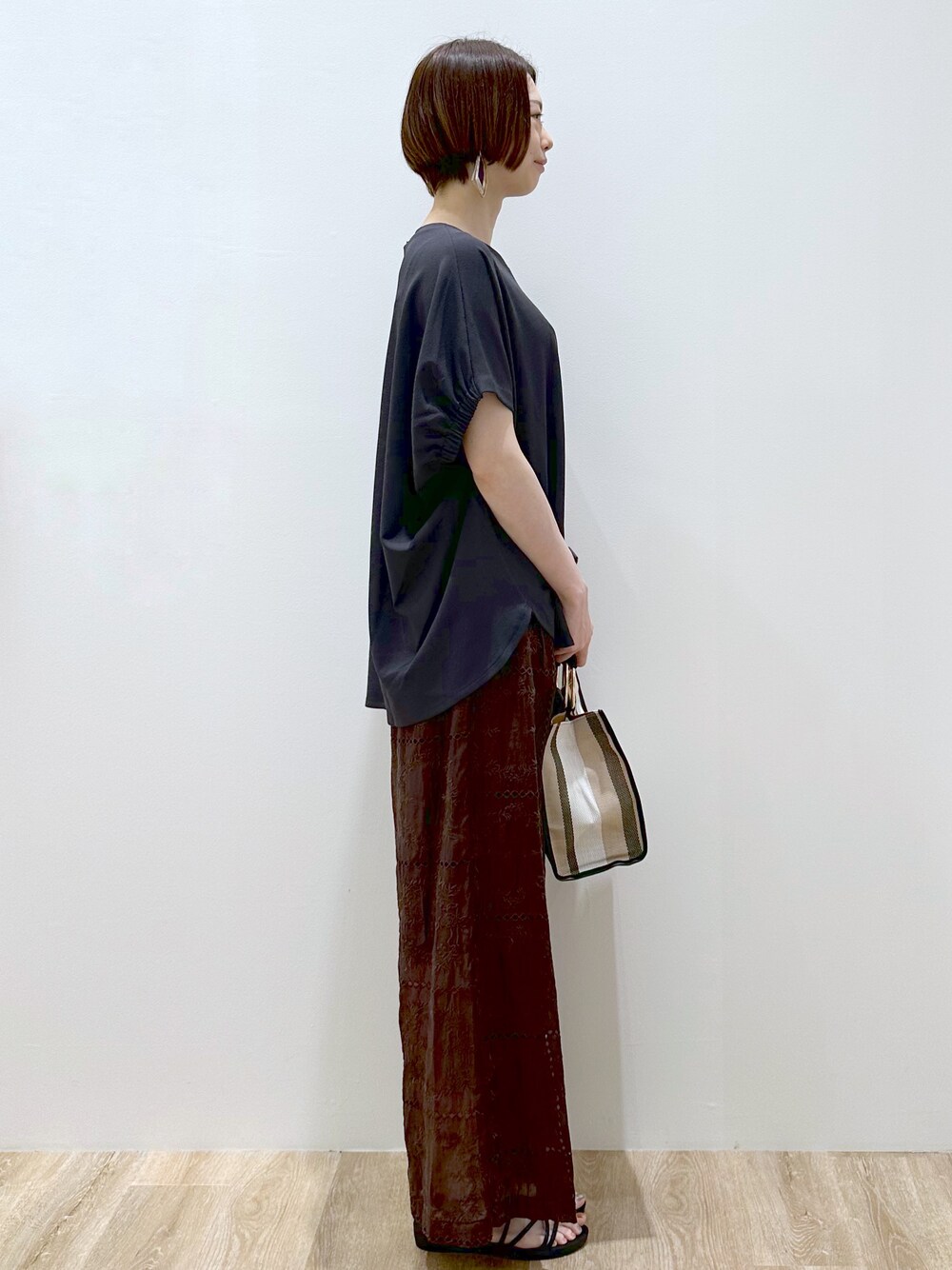 グレー系のTシャツ/カットソー、ブラウン系のその他パンツ、ブラック系のトートバッグを着用したレディースの春コーディネートの2枚目の写真