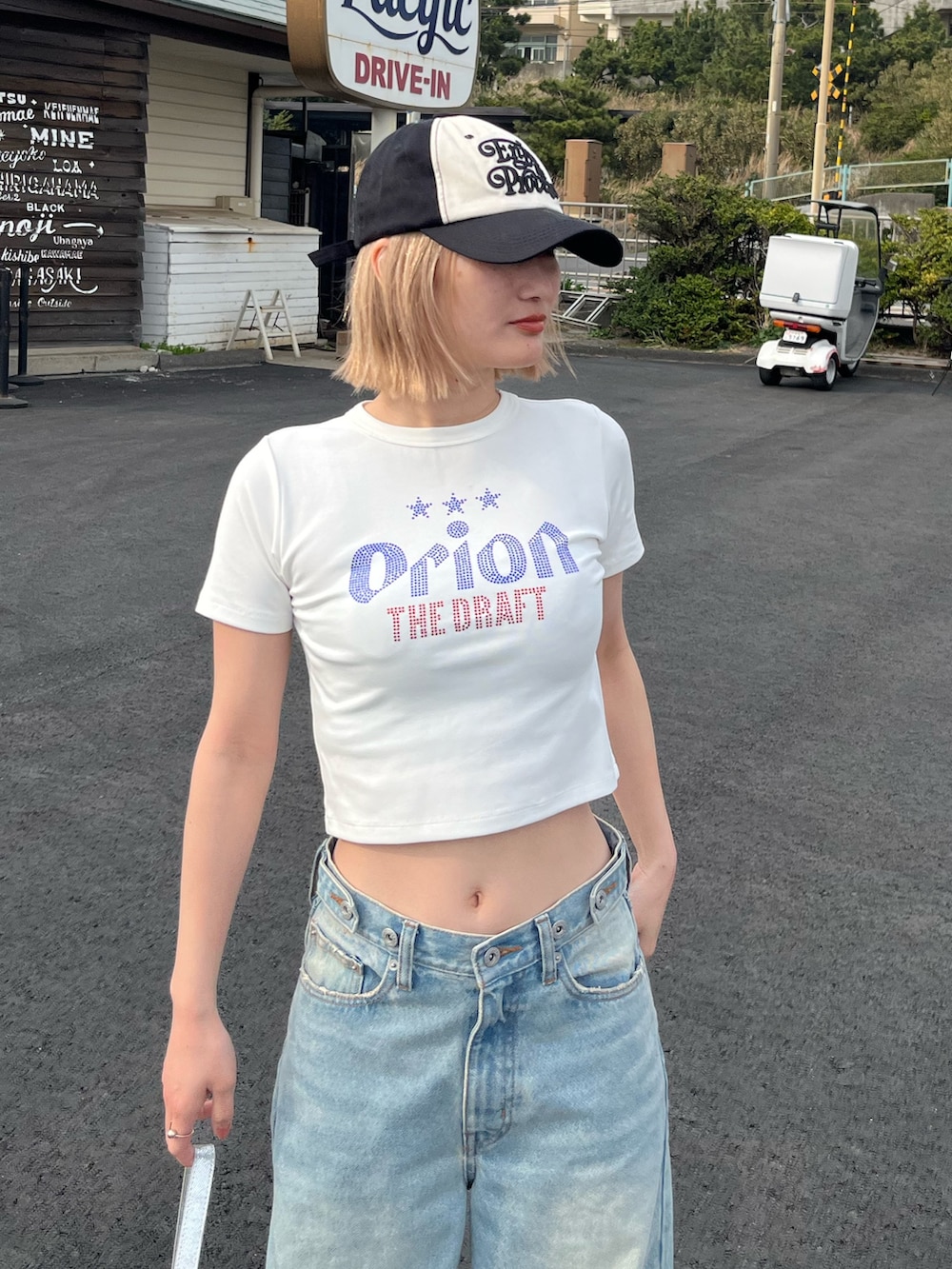 ホワイト系のTシャツ/カットソー、ブルー系のデニムパンツ、シルバー系のショルダーバッグを着用したレディースの春コーディネートの2枚目の写真