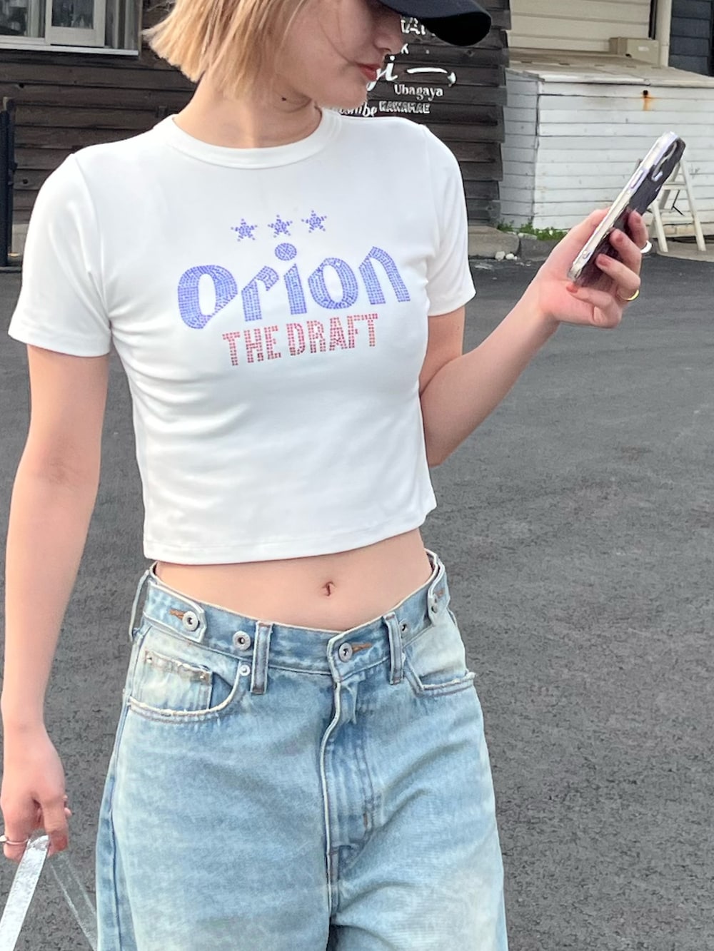 ホワイト系のTシャツ/カットソー、ブルー系のデニムパンツ、シルバー系のショルダーバッグを着用したレディースの春コーディネートの4枚目の写真