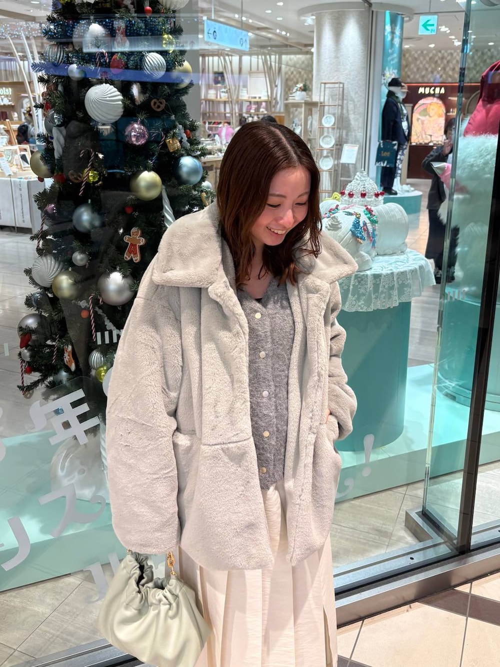 グレー系のその他アウター、グリーン系のショルダーバッグ、ホワイト系のスカートを着用したレディースの秋コーディネートの2枚目の写真