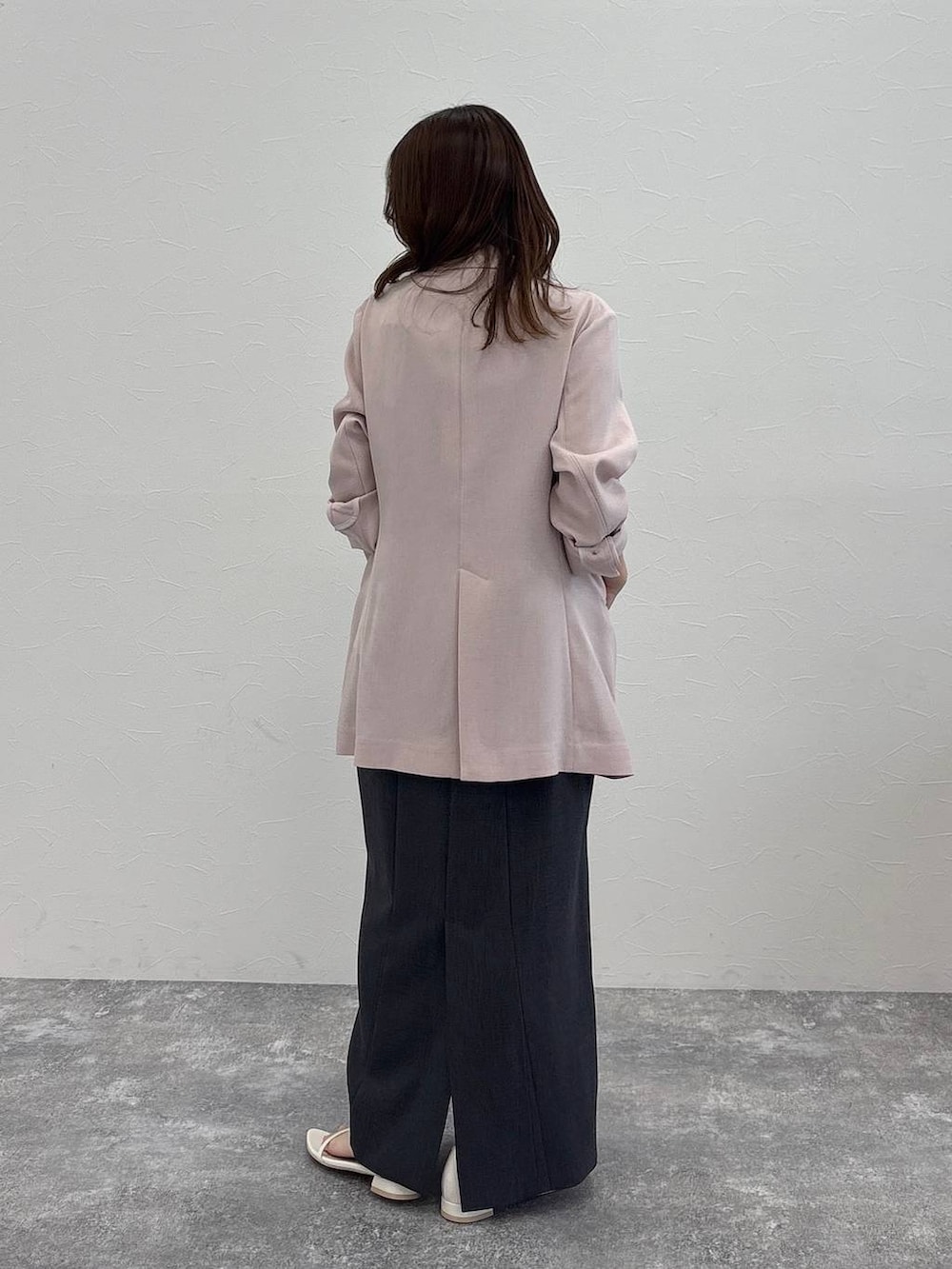 ピンク系のノーカラージャケット、グレー系のワンピース、ホワイト系のサンダルを着用したレディースの春コーディネートの4枚目の写真