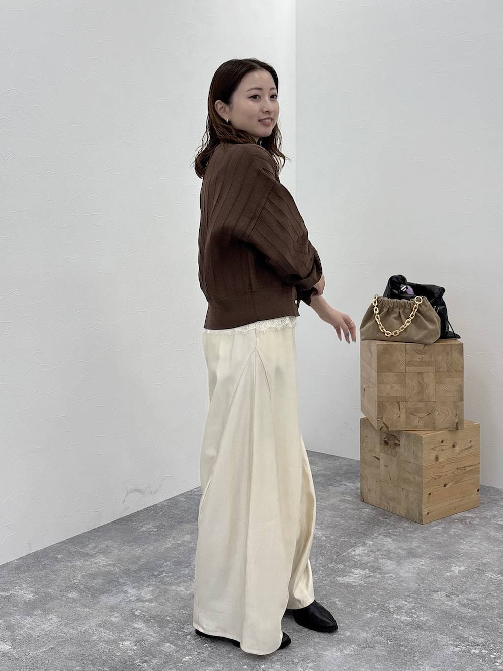 ブラック系のブーツ、ブラウン系のカーディガン/ボレロ、ホワイト系のその他パンツを着用したレディースの秋コーディネートの3枚目の写真