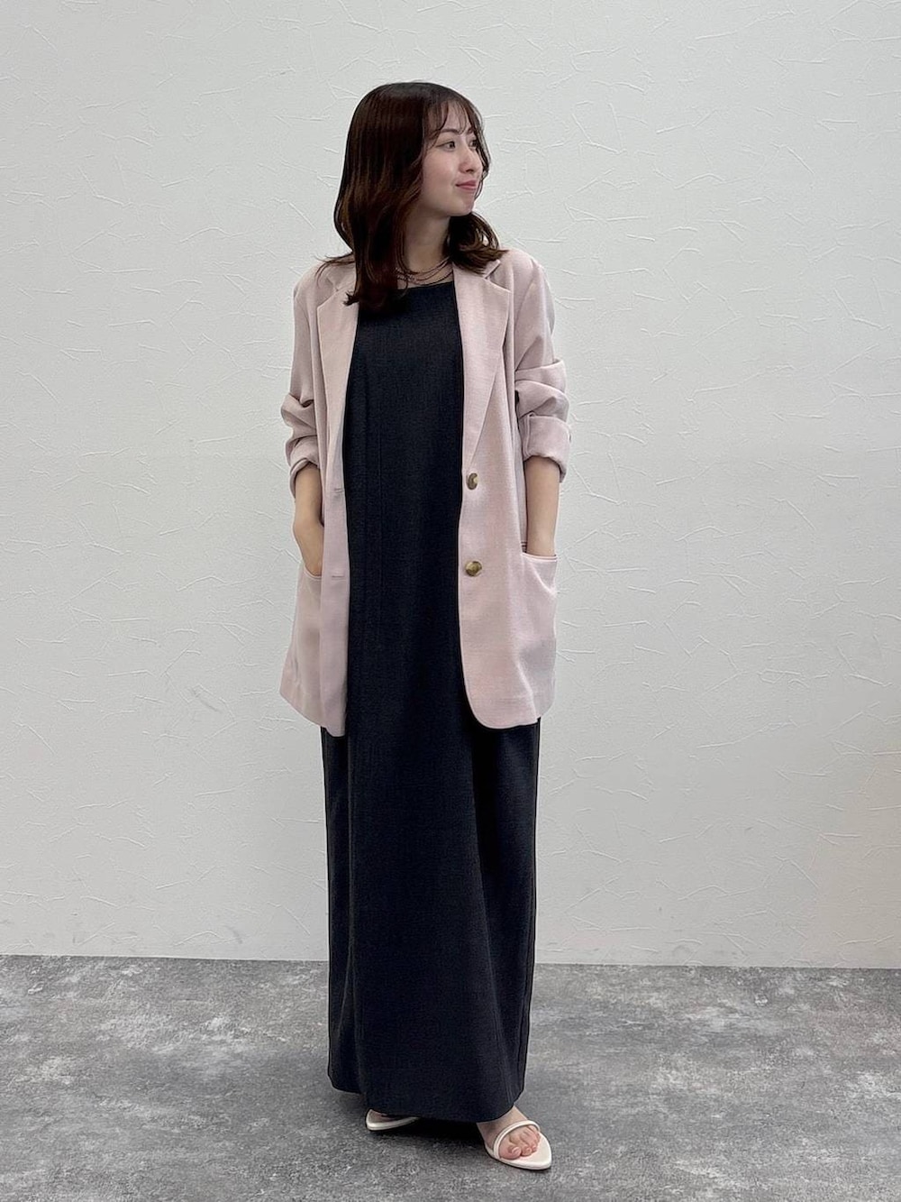 ピンク系のノーカラージャケット、グレー系のワンピース、ホワイト系のサンダルを着用したレディースの春コーディネートの2枚目の写真