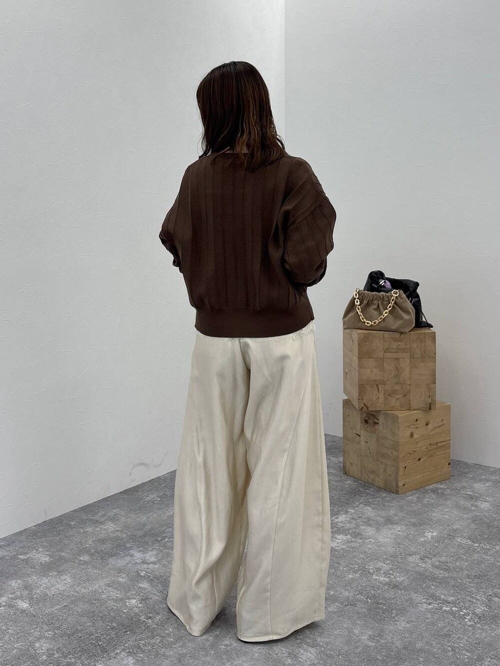 ブラック系のブーツ、ブラウン系のカーディガン/ボレロ、ホワイト系のその他パンツを着用したレディースの秋コーディネートの4枚目の写真