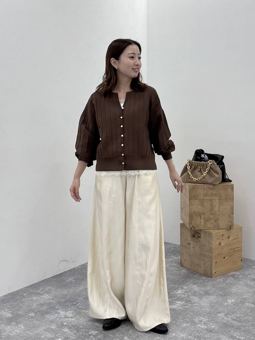 ブラック系のブーツ、ブラウン系のカーディガン/ボレロ、ホワイト系のその他パンツを着用したレディースの秋コーディネートの2枚目の写真