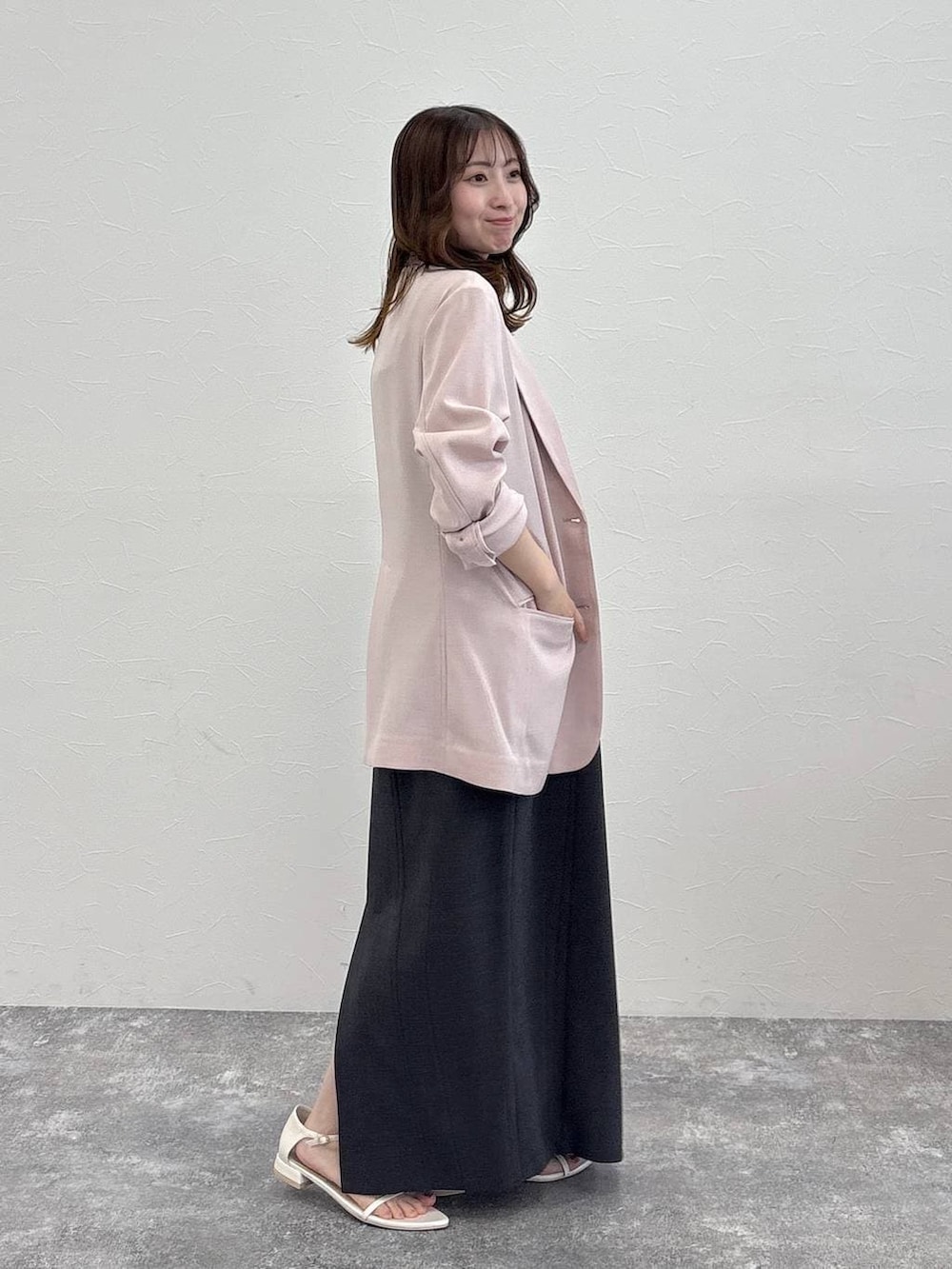 ピンク系のノーカラージャケット、グレー系のワンピース、ホワイト系のサンダルを着用したレディースの春コーディネートの3枚目の写真