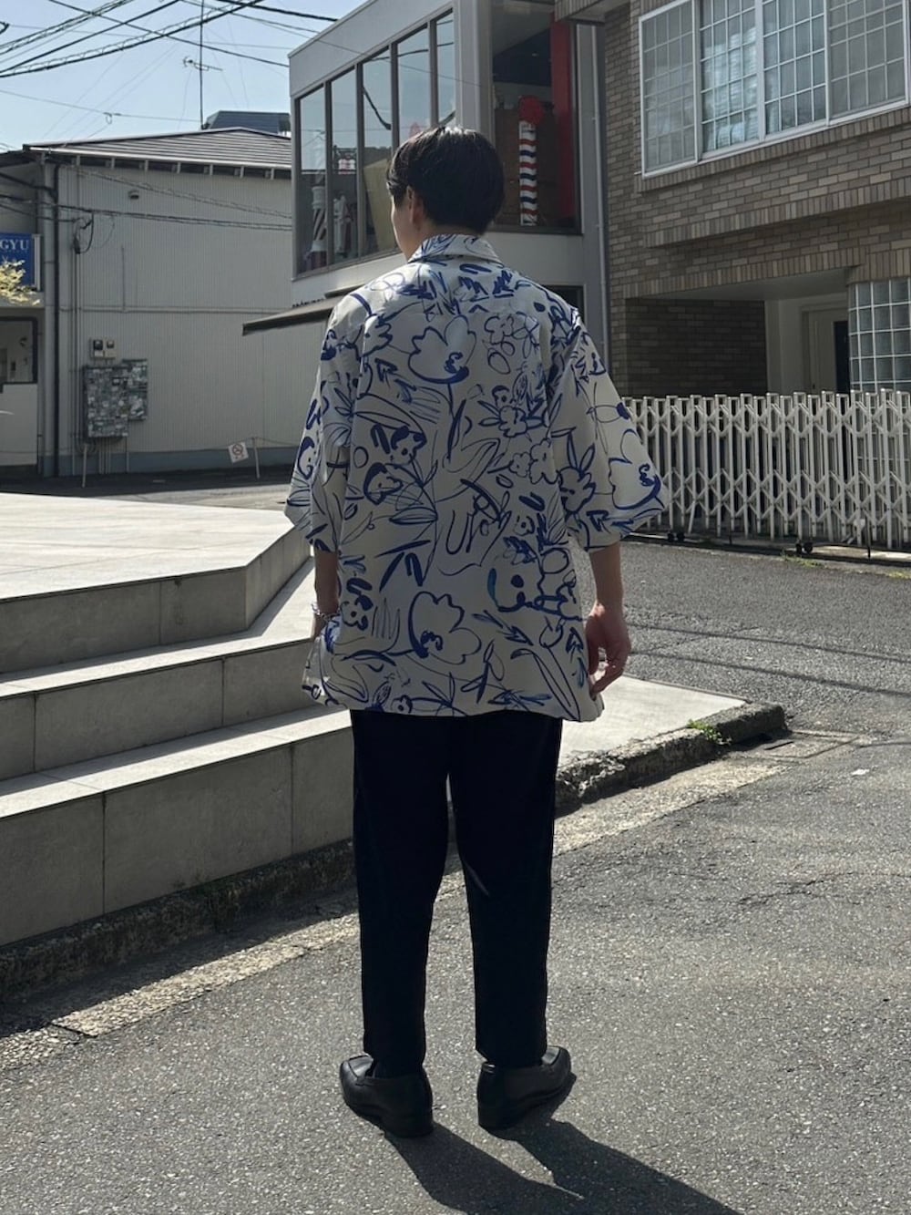 ブラック系のスラックスを着用したメンズの春コーディネートの3枚目の写真