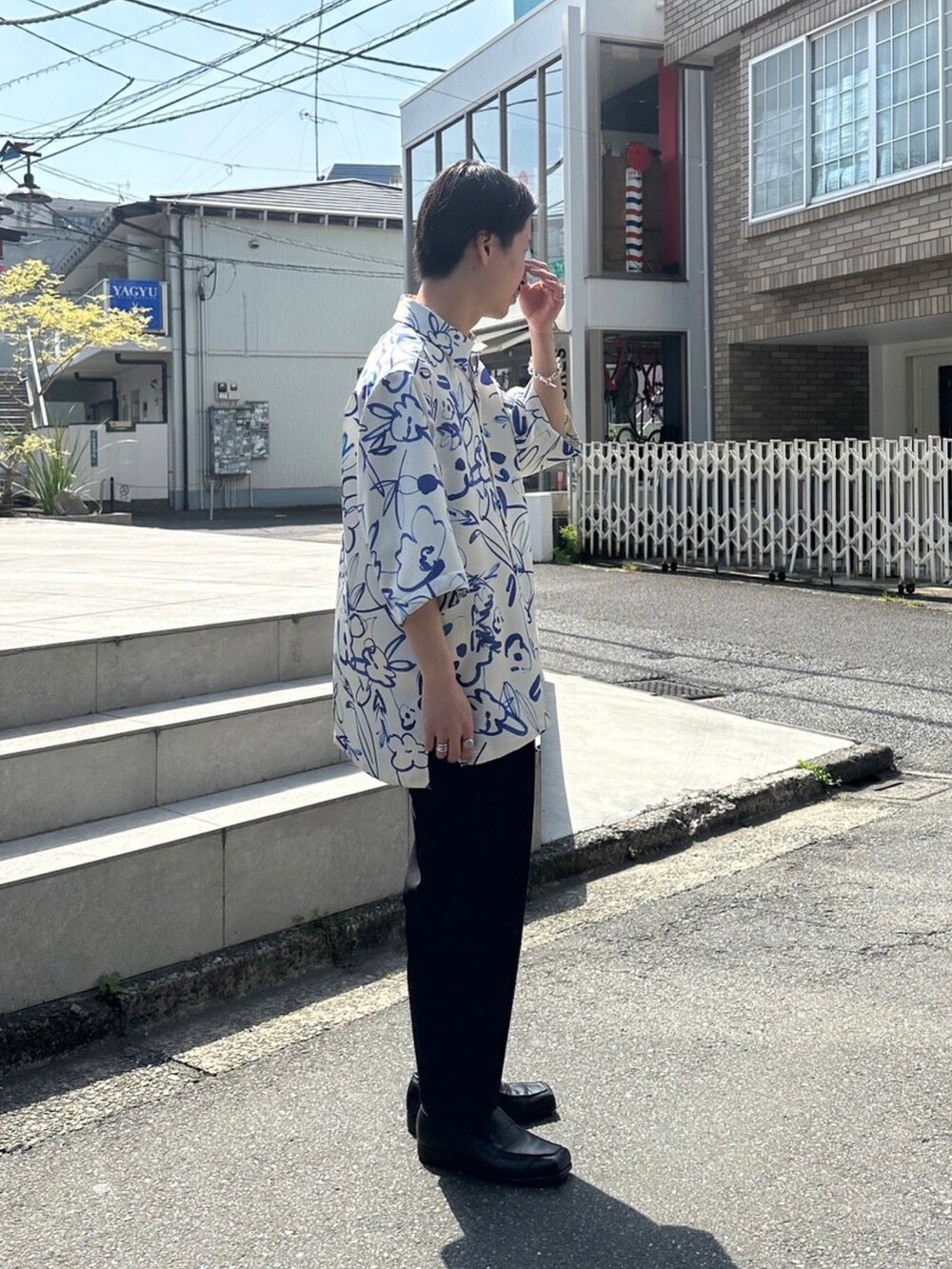 ブラック系のスラックスを着用したメンズの春コーディネートの2枚目の写真