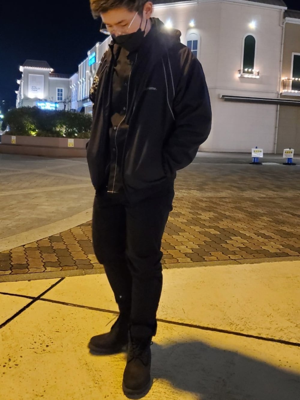 ブラック系のブルゾン、ブラック系のチノパンツ、ブラック系のブーツを着用したメンズの秋コーディネートの2枚目の写真