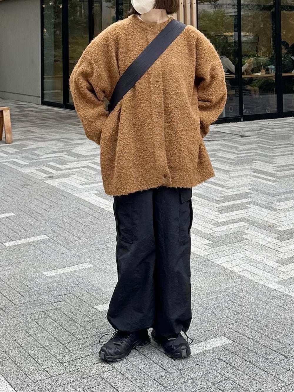 オレンジ系のカーディガン/ボレロ、ブラック系のカーゴパンツ、ブラック系のスニーカーを着用したレディースの秋コーディネートの2枚目の写真