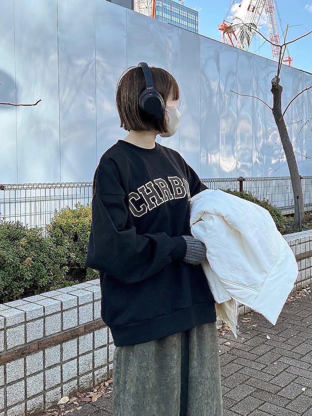 ブラック系のスウェット、グリーン系のその他パンツ、ホワイト系のその他アウターを着用したレディースの冬コーディネートの2枚目の写真