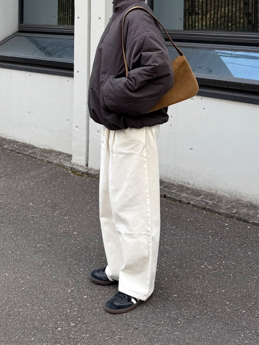 ホワイト系のその他パンツ、グレー系のダウンジャケット/コート、イエロー系のハンドバッグを着用したレディースの冬コーディネートの2枚目の写真