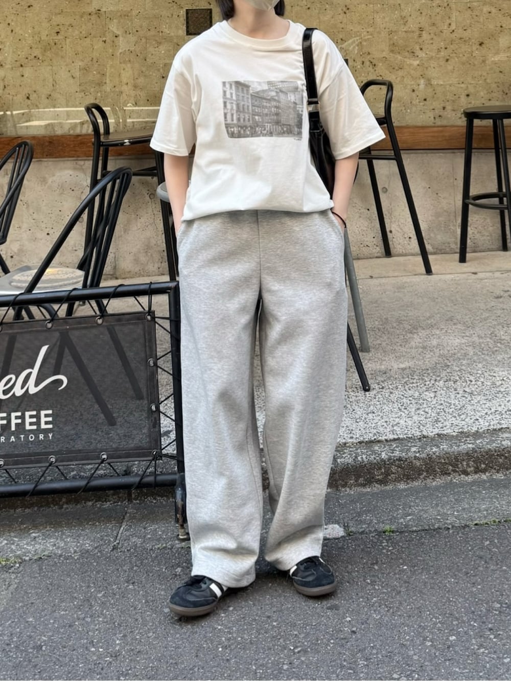 ホワイト系のTシャツ/カットソー、グレー系のスウェットパンツ、ブラック系のハンドバッグを着用したレディースの春コーディネートの2枚目の写真