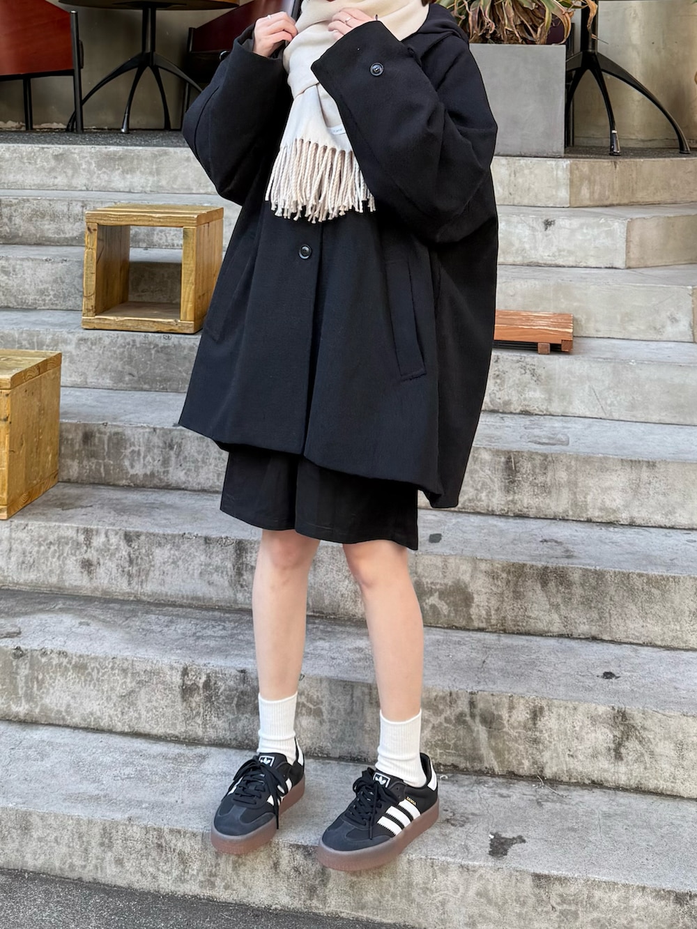 ブラック系のスニーカー、ブラック系のその他パンツ、ブラック系のステンカラーコートを着用したレディースの冬コーディネートの2枚目の写真