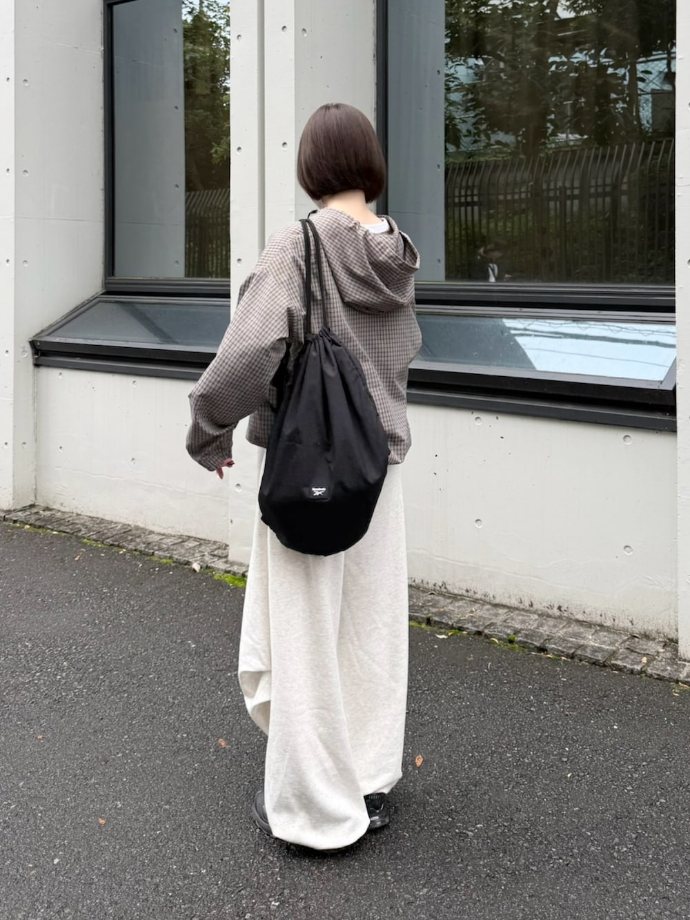ブラック系のスニーカー、ブラック系のショルダーバッグ、その他のパーカーを着用したレディースの秋コーディネートの2枚目の写真