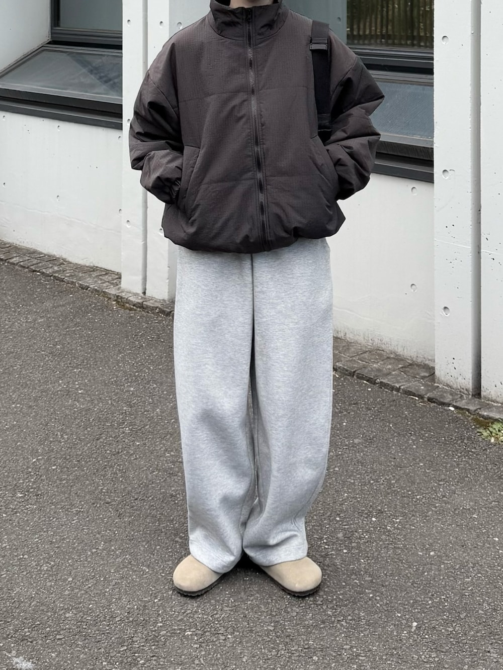 グレー系のダウンジャケット/コート、ブラック系のショルダーバッグ、ベージュ系のサンダルを着用したレディースの冬コーディネートの2枚目の写真