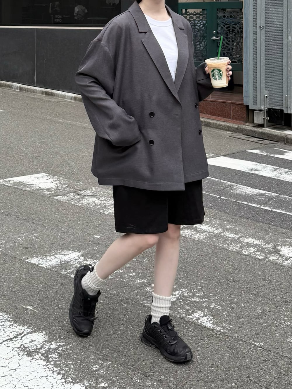 グレー系のテーラードジャケット、ブラック系のスニーカー、ブラック系のその他パンツを着用したレディースの秋コーディネートの2枚目の写真