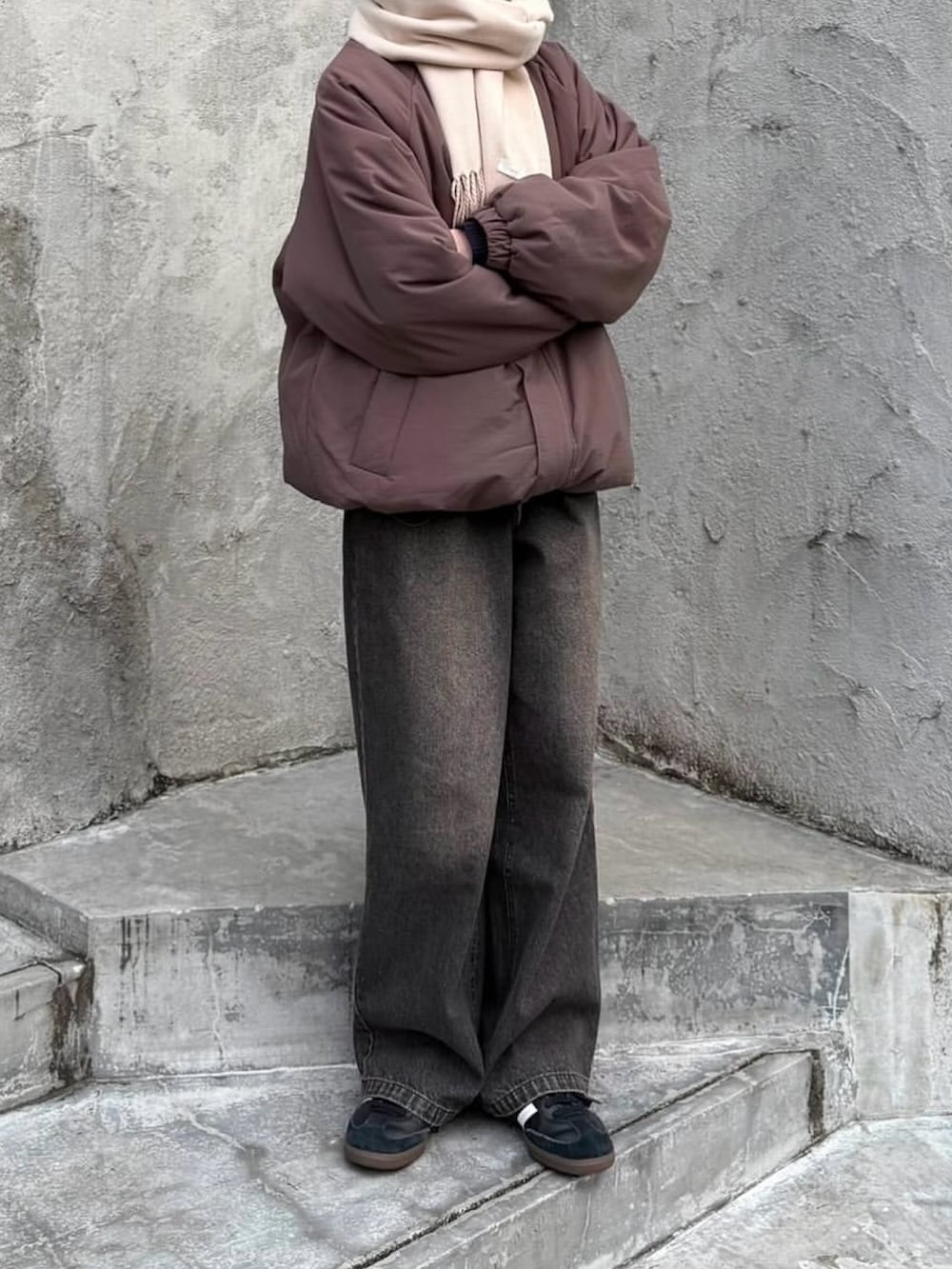 グレー系のその他アウター、ブラック系のデニムパンツ、ブラック系のスニーカーを着用したレディースの冬コーディネートの2枚目の写真