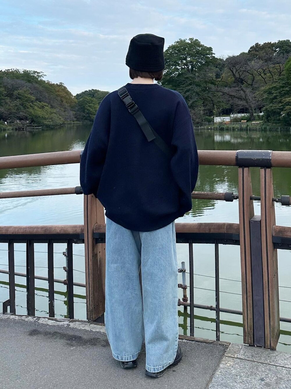 ブルー系のニット/セーター、ブルー系のデニムパンツ、ブラック系のスニーカーを着用したレディースの秋コーディネートの3枚目の写真