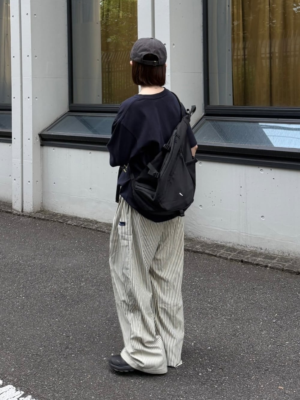 ブルー系のTシャツ/カットソー、ブラック系のスニーカー、ブラック系のショルダーバッグを着用したレディースの夏コーディネートの3枚目の写真