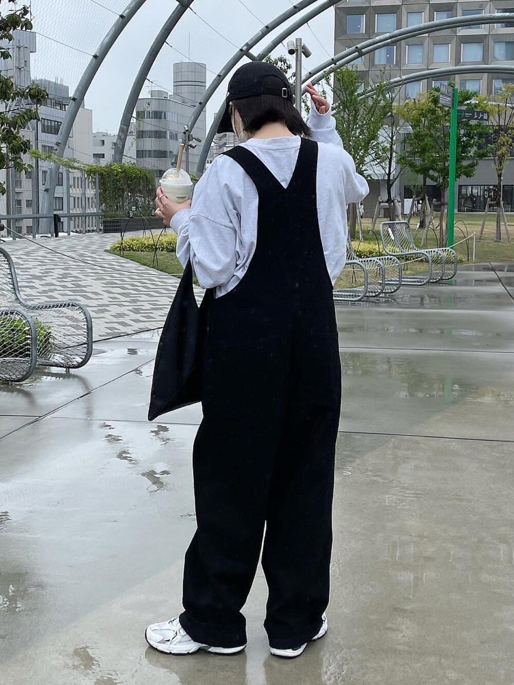 ブラック系のトートバッグ、グレー系のTシャツ/カットソー、ブラック系のサロペット/オーバーオールを着用したレディースの春コーディネートの2枚目の写真