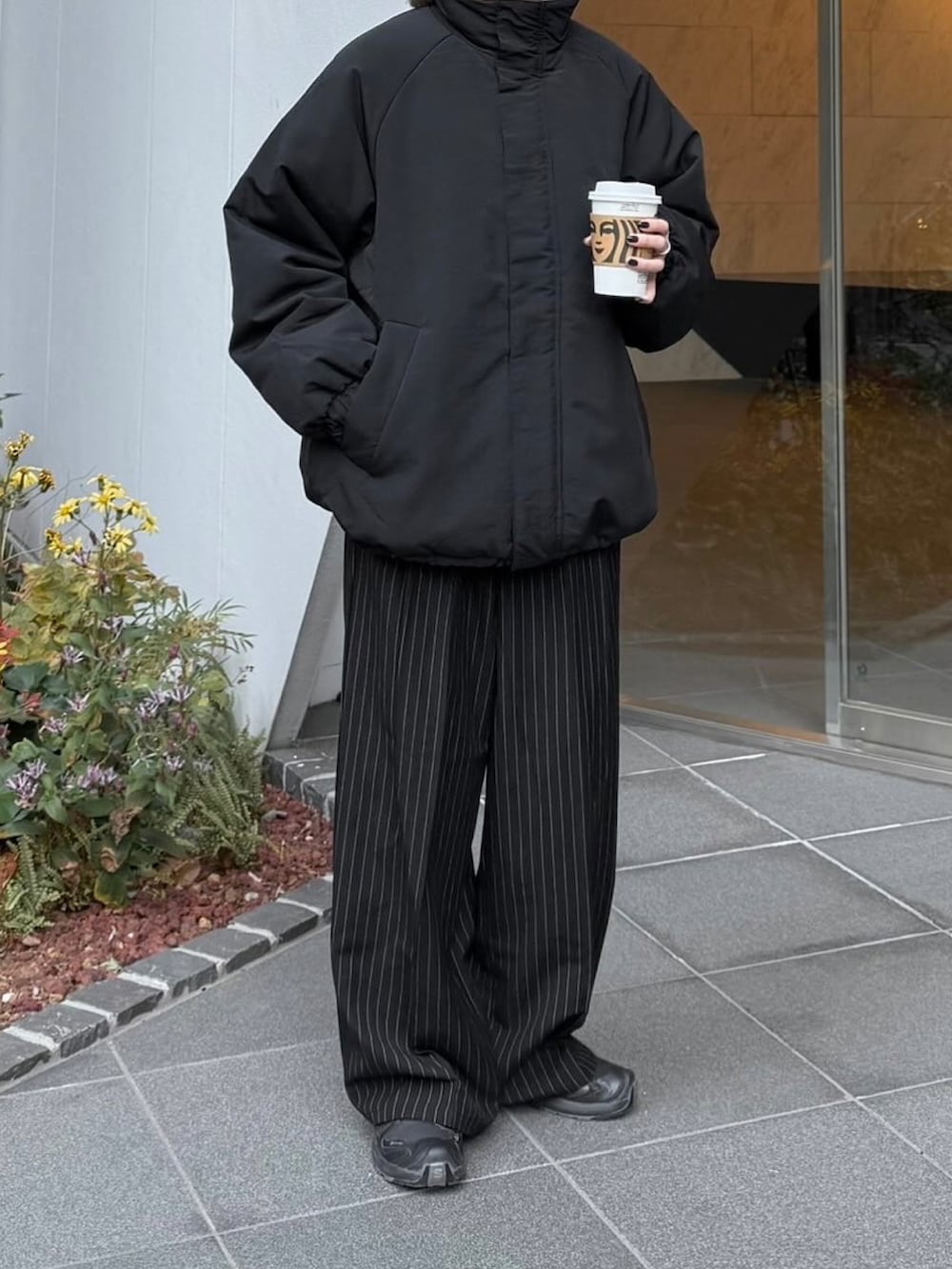 ブラック系のその他アウター、ブラック系のスラックス、ブラック系のスニーカーを着用したレディースの冬コーディネートの2枚目の写真