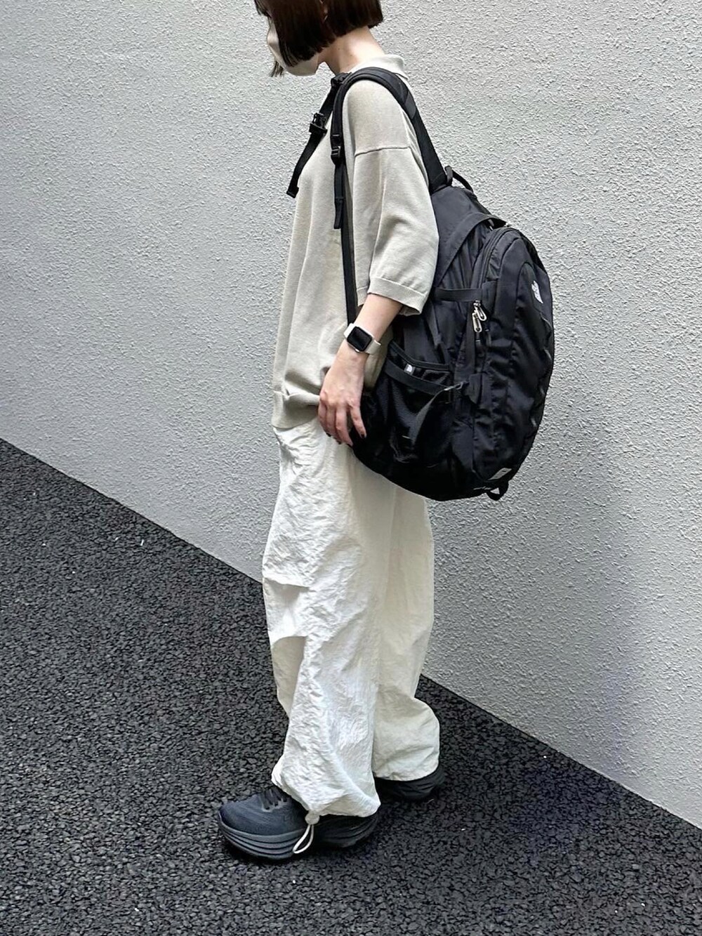 グレー系のポロシャツ、ホワイト系のその他パンツ、ブラック系のバックパック/リュックを着用したレディースの夏コーディネートの2枚目の写真