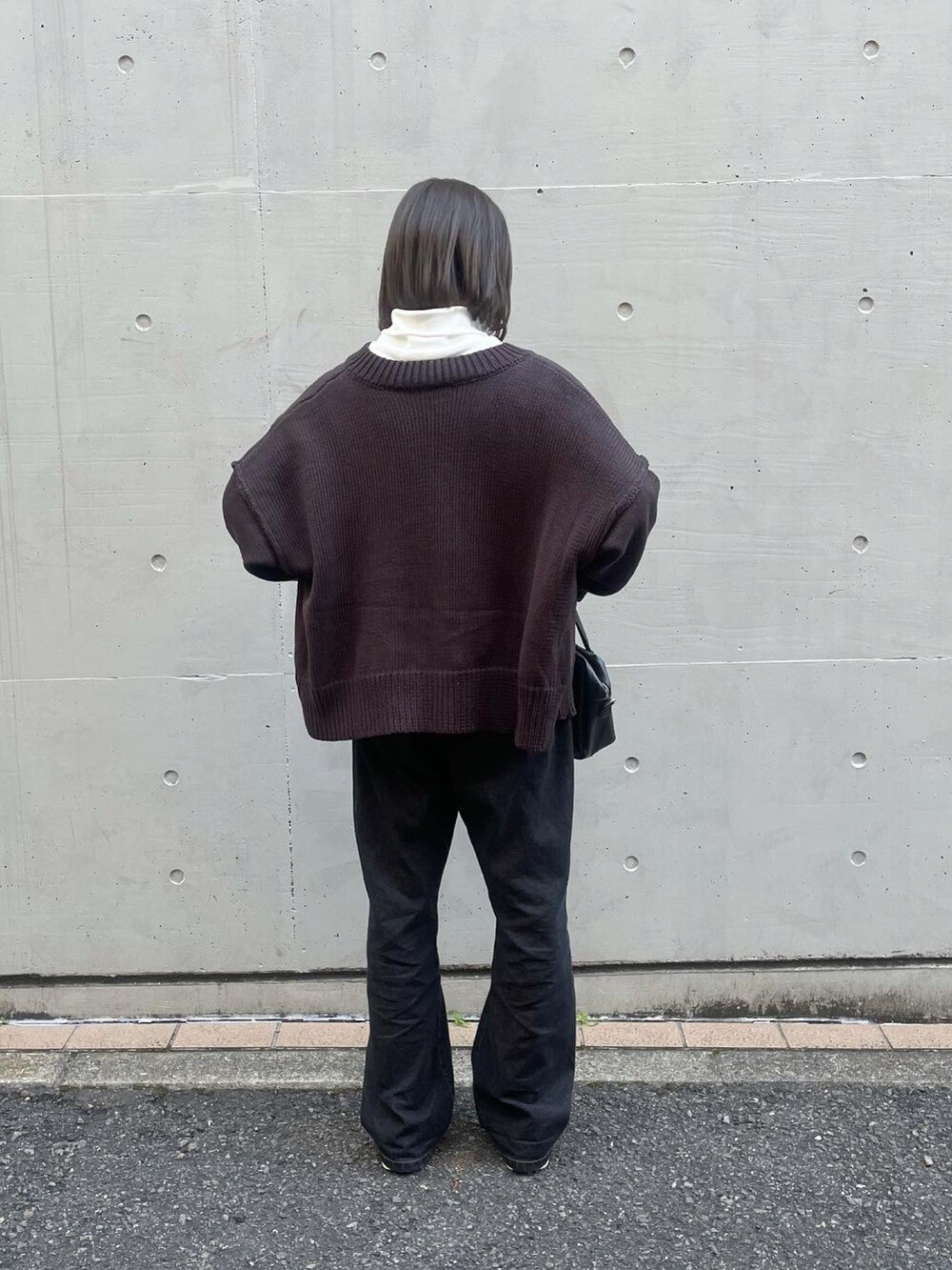 ブラウン系のカーディガン/ボレロ、ホワイト系のTシャツ/カットソー、ブラック系のデニムパンツを着用したレディースの秋コーディネートの3枚目の写真