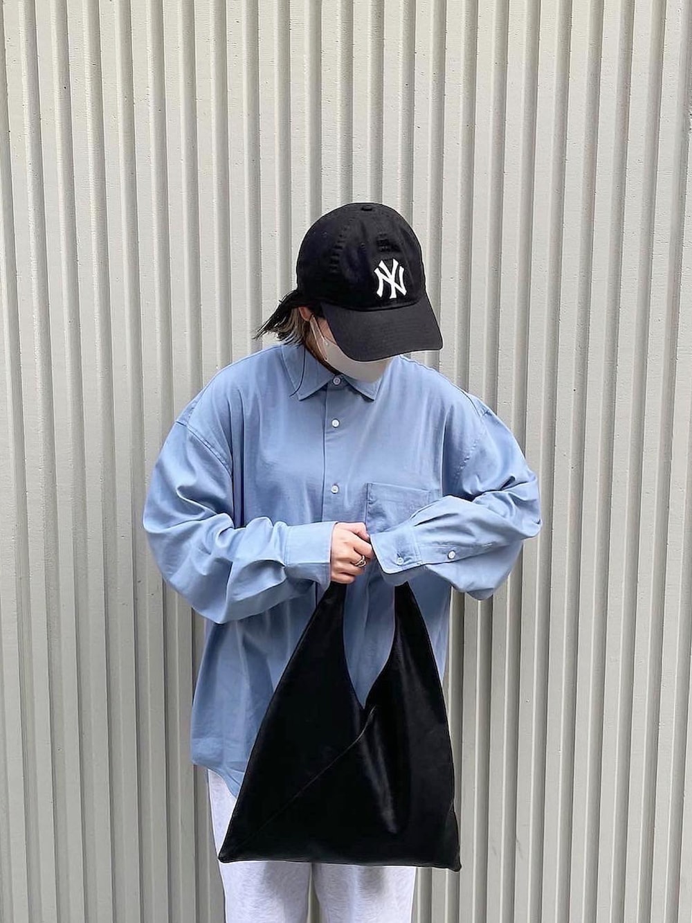 ブルー系のシャツ/ブラウス、グレー系のスウェットパンツ、ブラック系のトートバッグを着用したレディースの春コーディネートの2枚目の写真