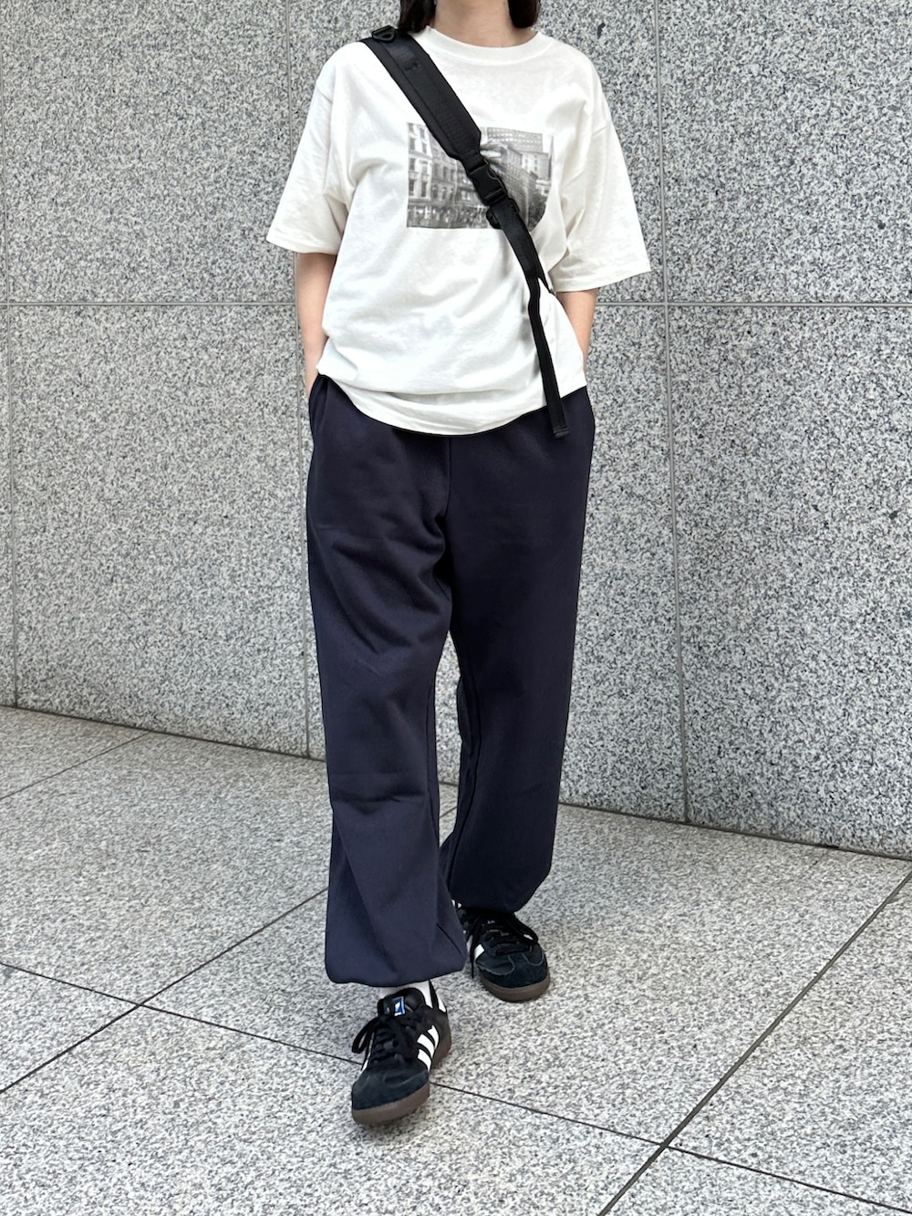 ホワイト系のTシャツ/カットソー、ブルー系のスウェットパンツ、ブラック系のショルダーバッグを着用したレディースの秋コーディネートの2枚目の写真