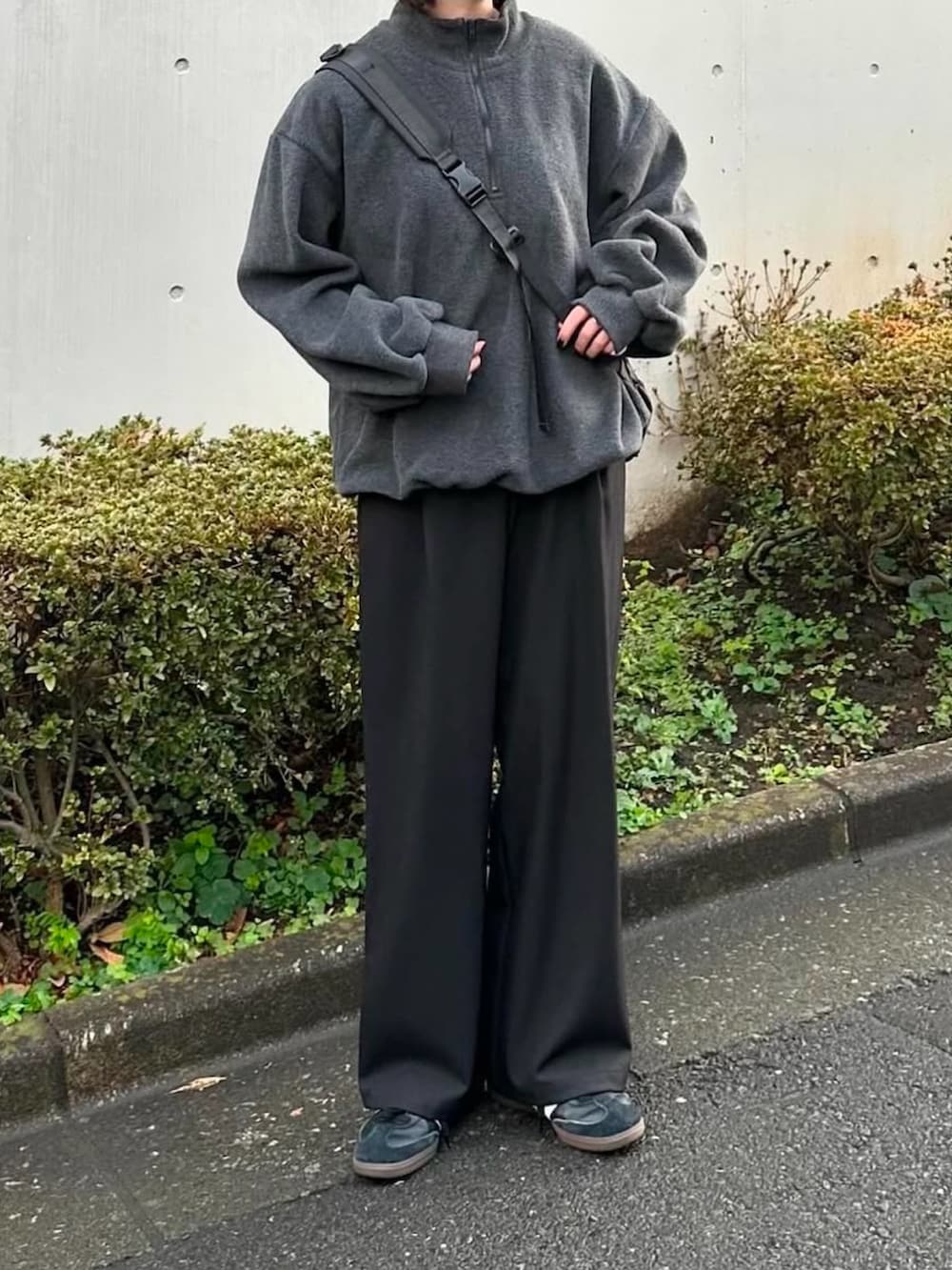 グレー系のスウェット、ブラック系のスラックス、ブラック系のショルダーバッグを着用したレディースの冬コーディネートの3枚目の写真