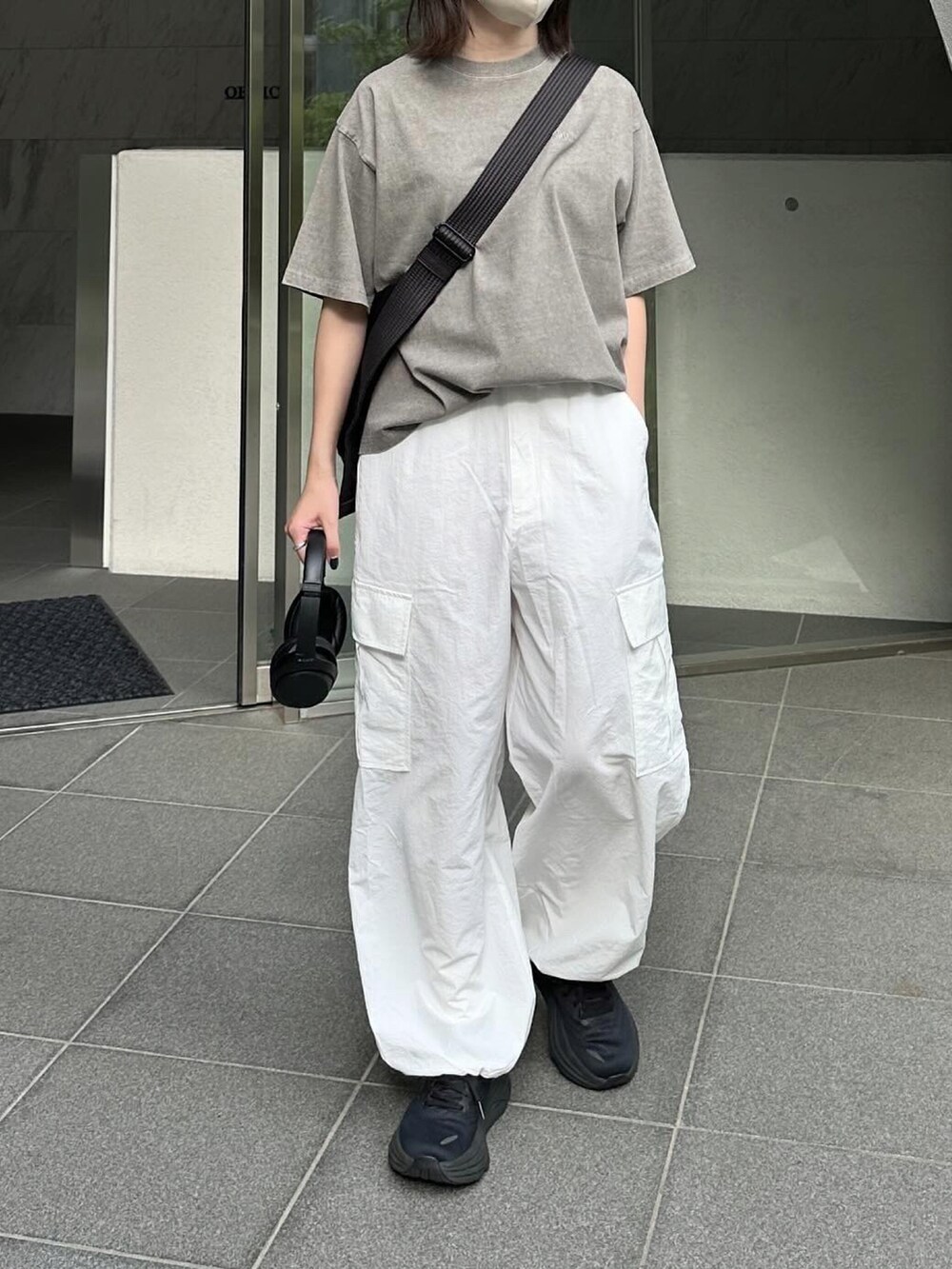 グレー系のTシャツ/カットソー、ホワイト系のカーゴパンツ、ブラック系のショルダーバッグを着用したレディースの春コーディネートの2枚目の写真