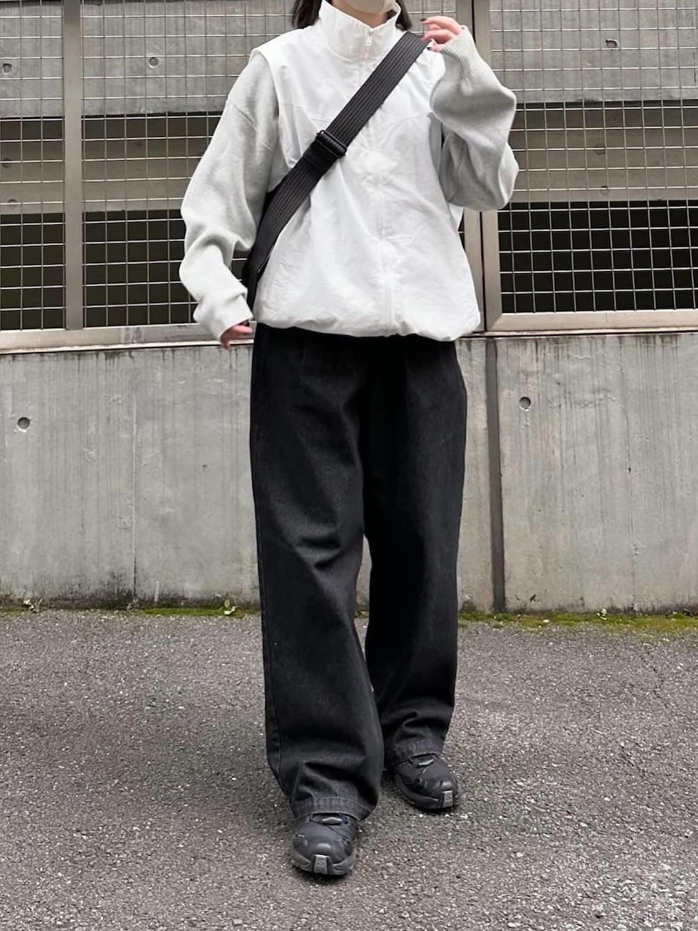 ホワイト系のベスト、グレー系のニット/セーター、ブラック系のデニムパンツを着用したレディースの春コーディネートの2枚目の写真