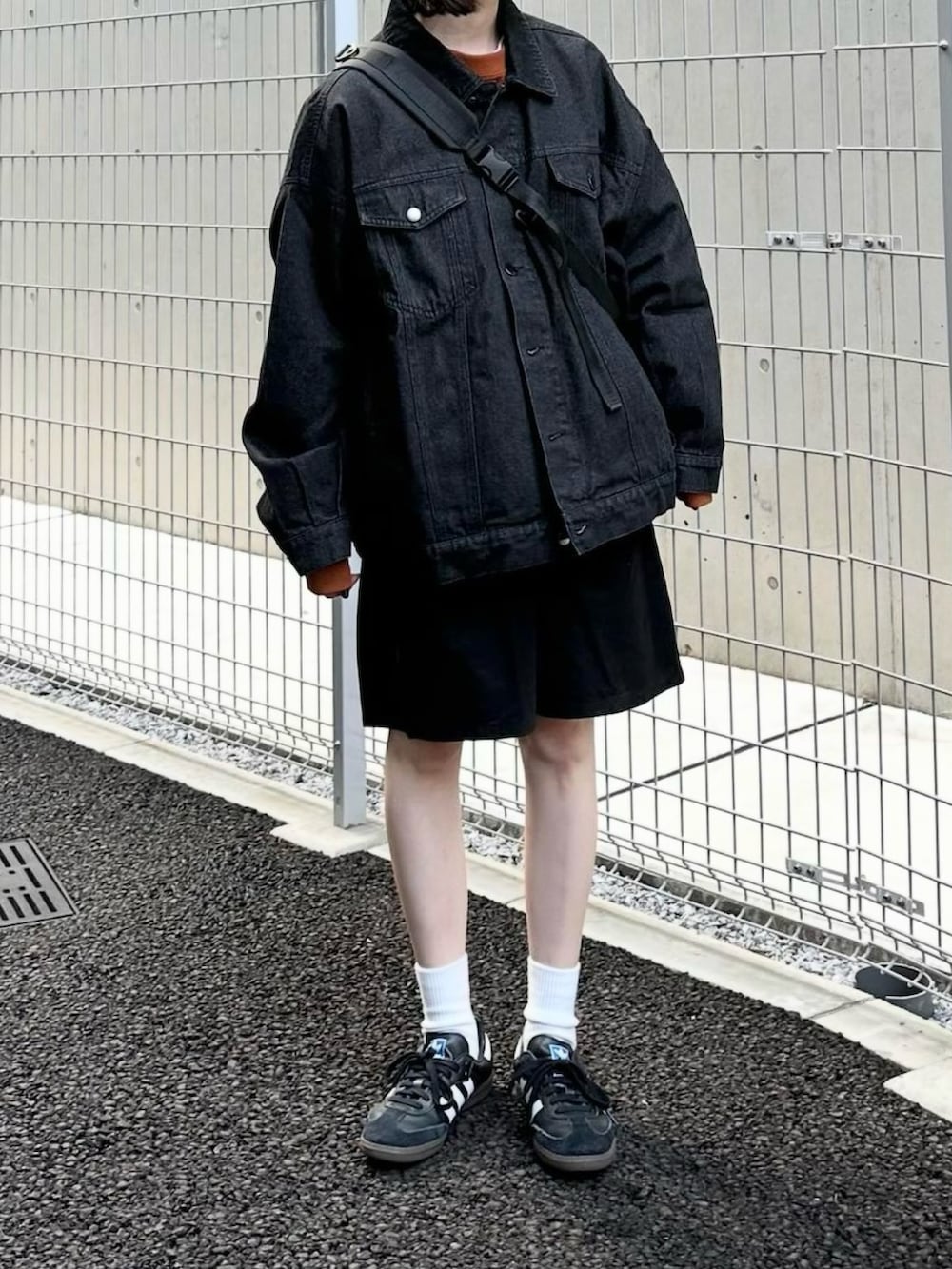 ブラック系のデニムジャケット、オレンジ系のスウェット、ブラック系のその他パンツを着用したレディースの秋コーディネートの3枚目の写真