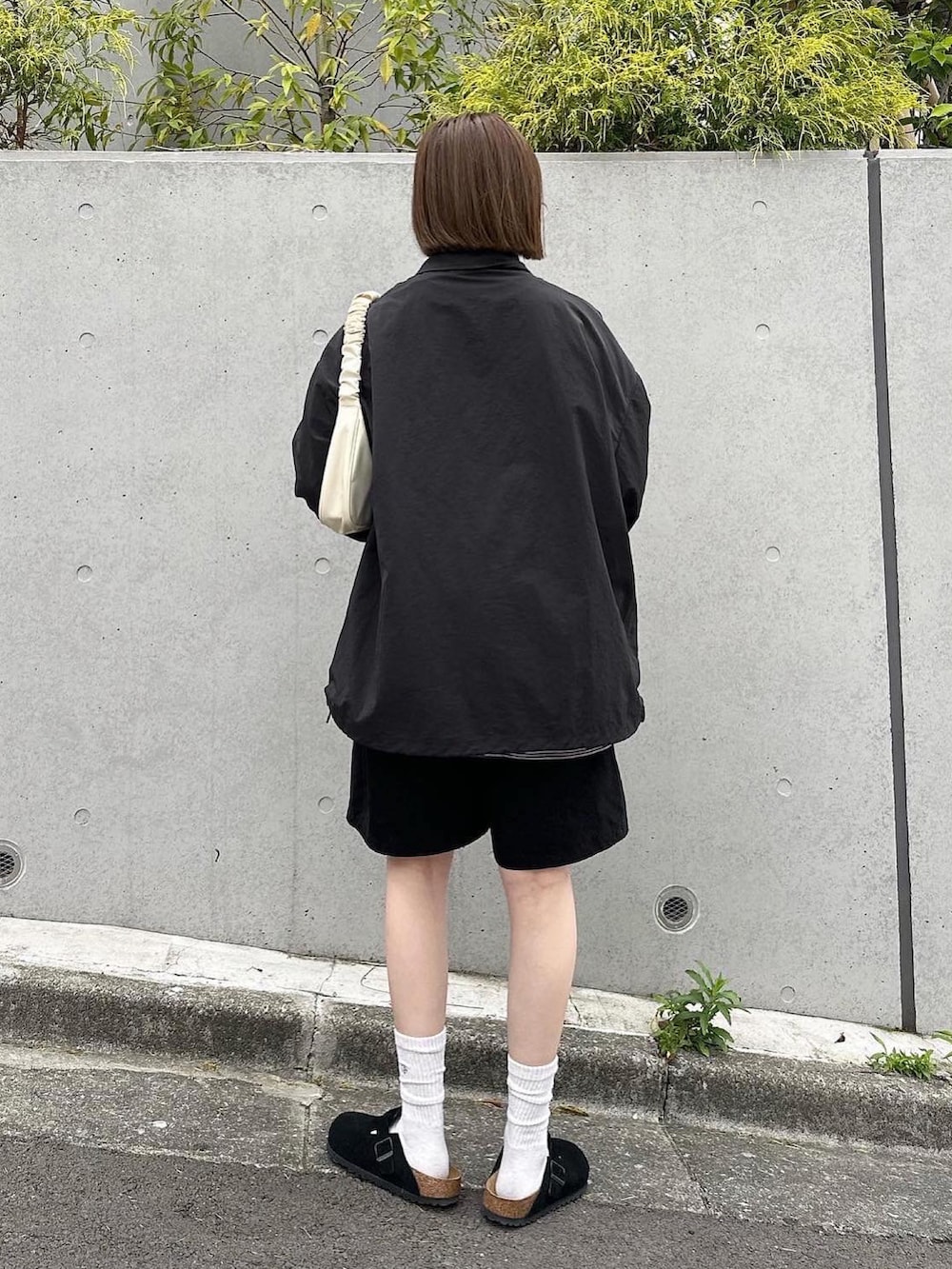 ブラック系のナイロンジャケット、ブラック系のその他パンツを着用したレディースの春コーディネートの3枚目の写真