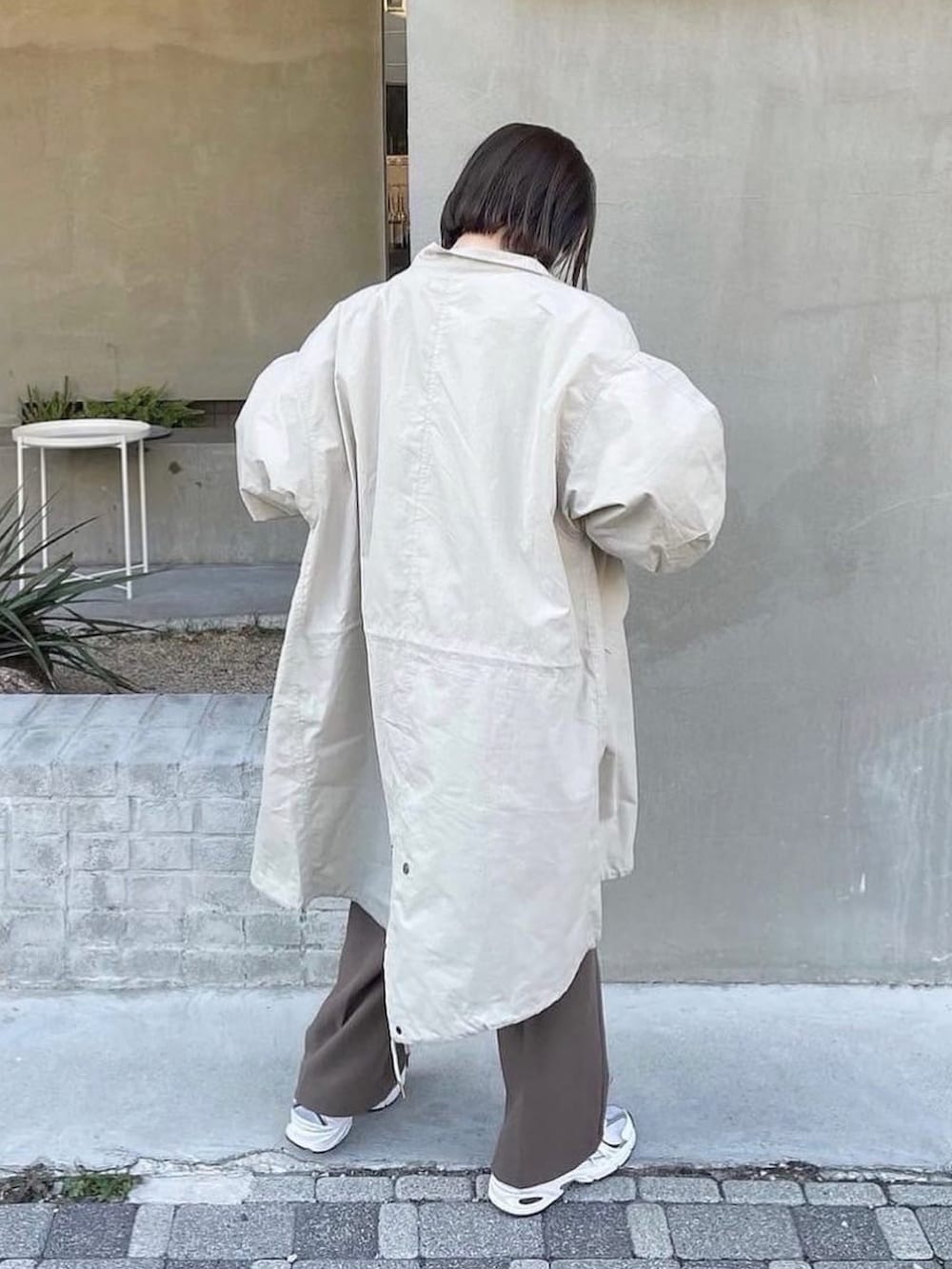 ベージュ系のモッズコート、ベージュ系のニット/セーター、ブラウン系のその他パンツを着用したレディースの秋コーディネートの2枚目の写真