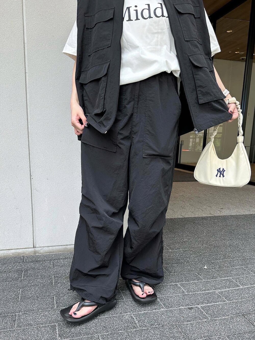 ブラック系のベスト、ブラック系のその他パンツ、ブラック系のサンダルを着用したレディースの夏コーディネートの5枚目の写真