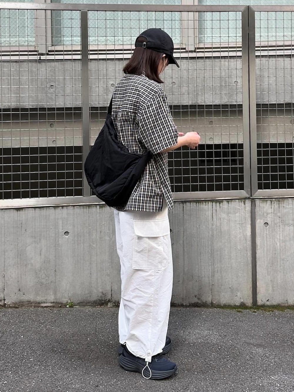 ブラック系のシャツ/ブラウス、ホワイト系のカーゴパンツ、ブラック系のスニーカーを着用したレディースの春コーディネートの3枚目の写真