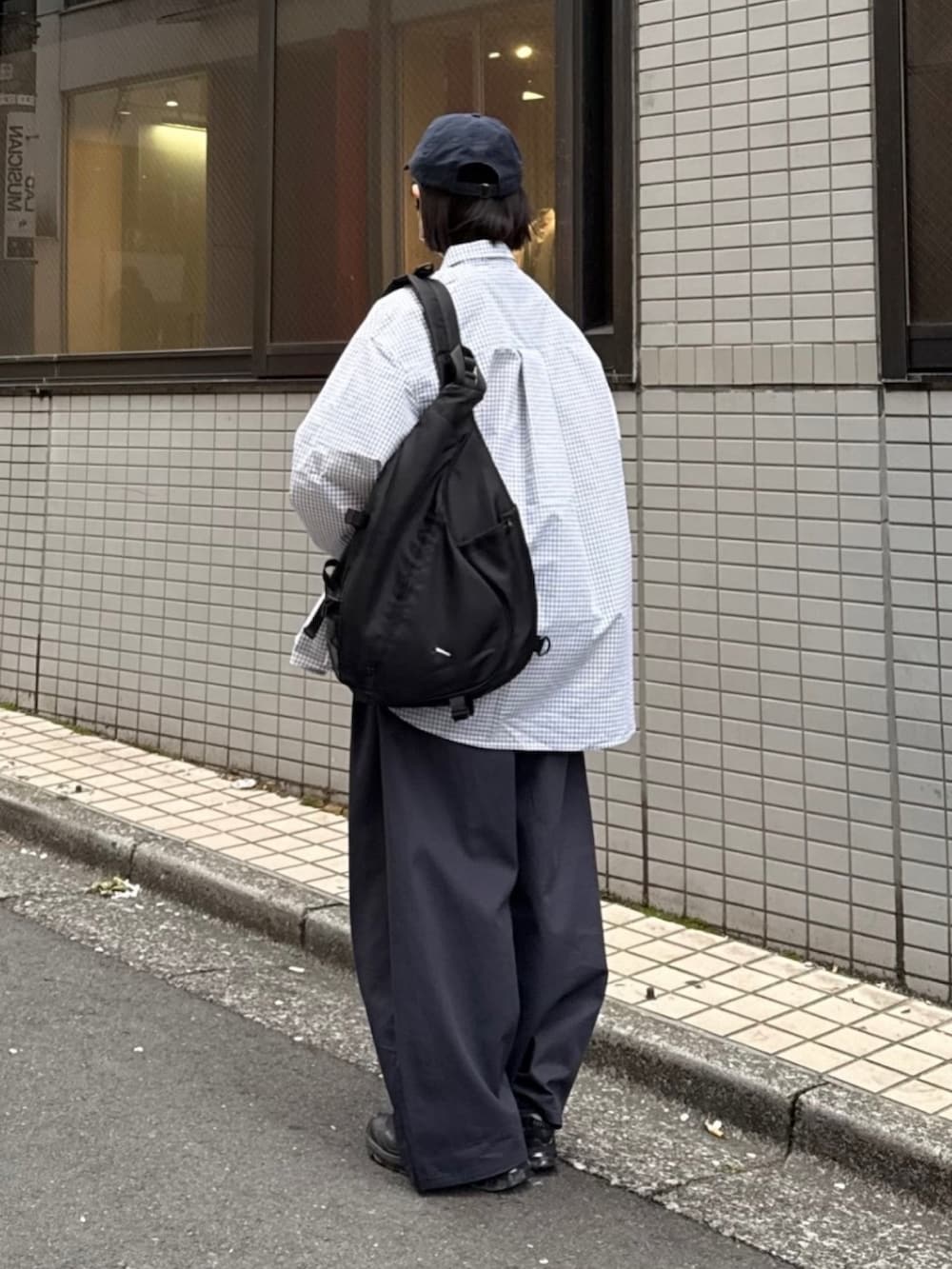 ブラック系のシャツ/ブラウス、ブラック系のスニーカー、ブラック系のショルダーバッグを着用したレディースの春コーディネートの2枚目の写真
