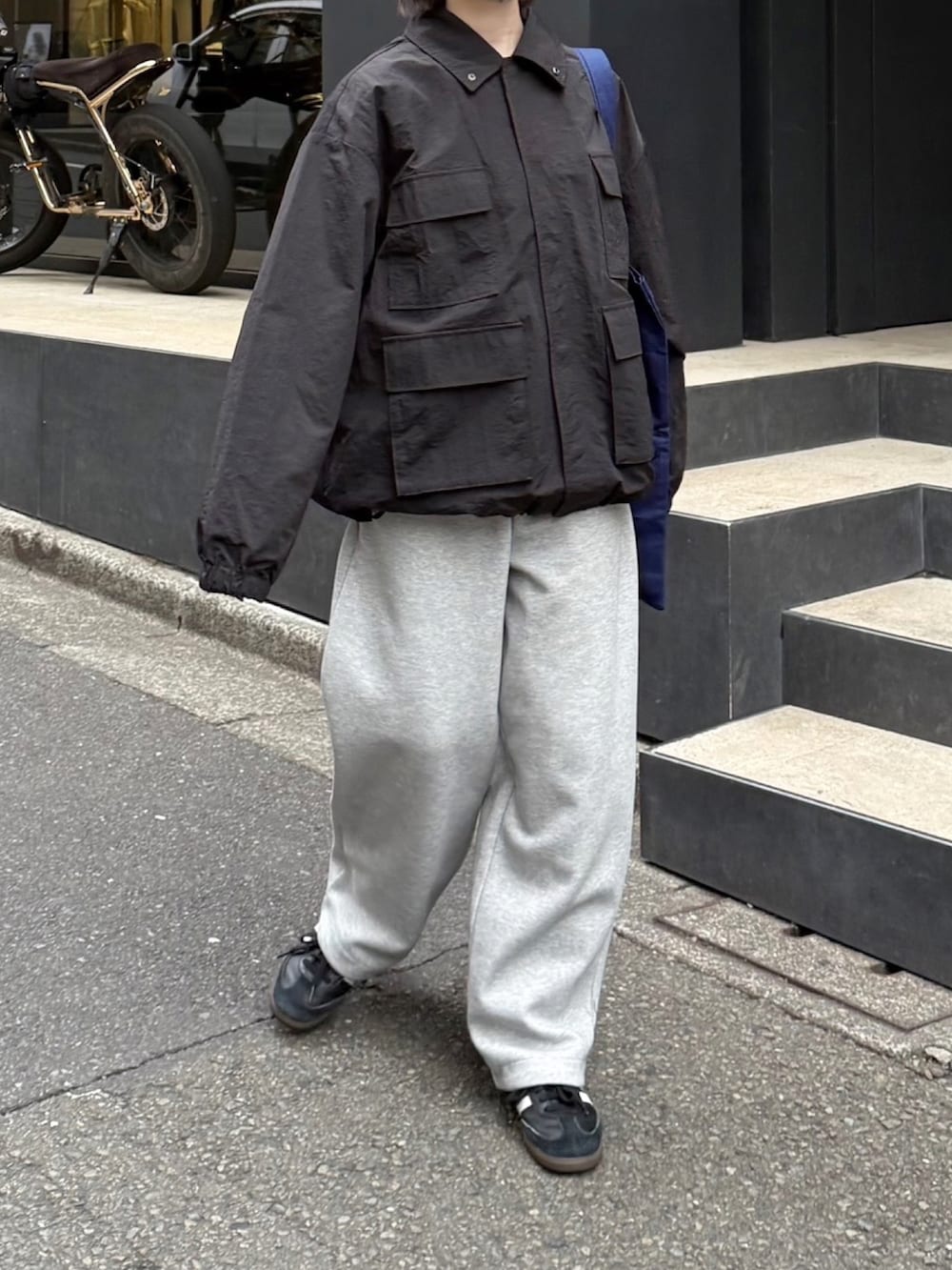 ブラック系のナイロンジャケット、ブラック系のスニーカー、グレー系のスウェットパンツを着用したレディースの冬コーディネートの2枚目の写真