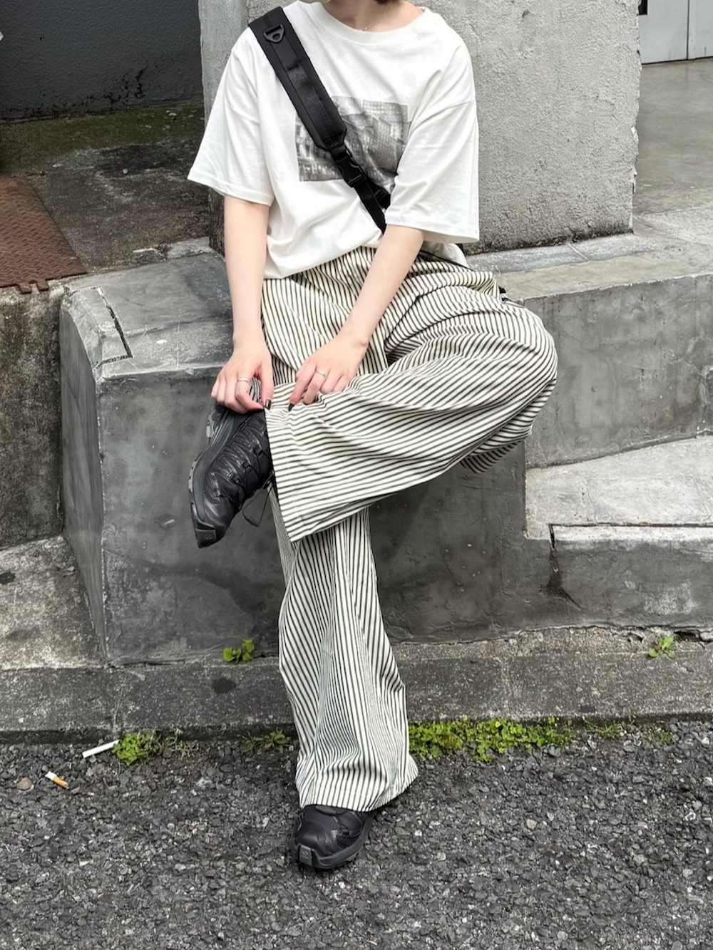 ホワイト系のTシャツ/カットソー、ブラック系のショルダーバッグ、ブラック系のスニーカーを着用したレディースの夏コーディネートの2枚目の写真